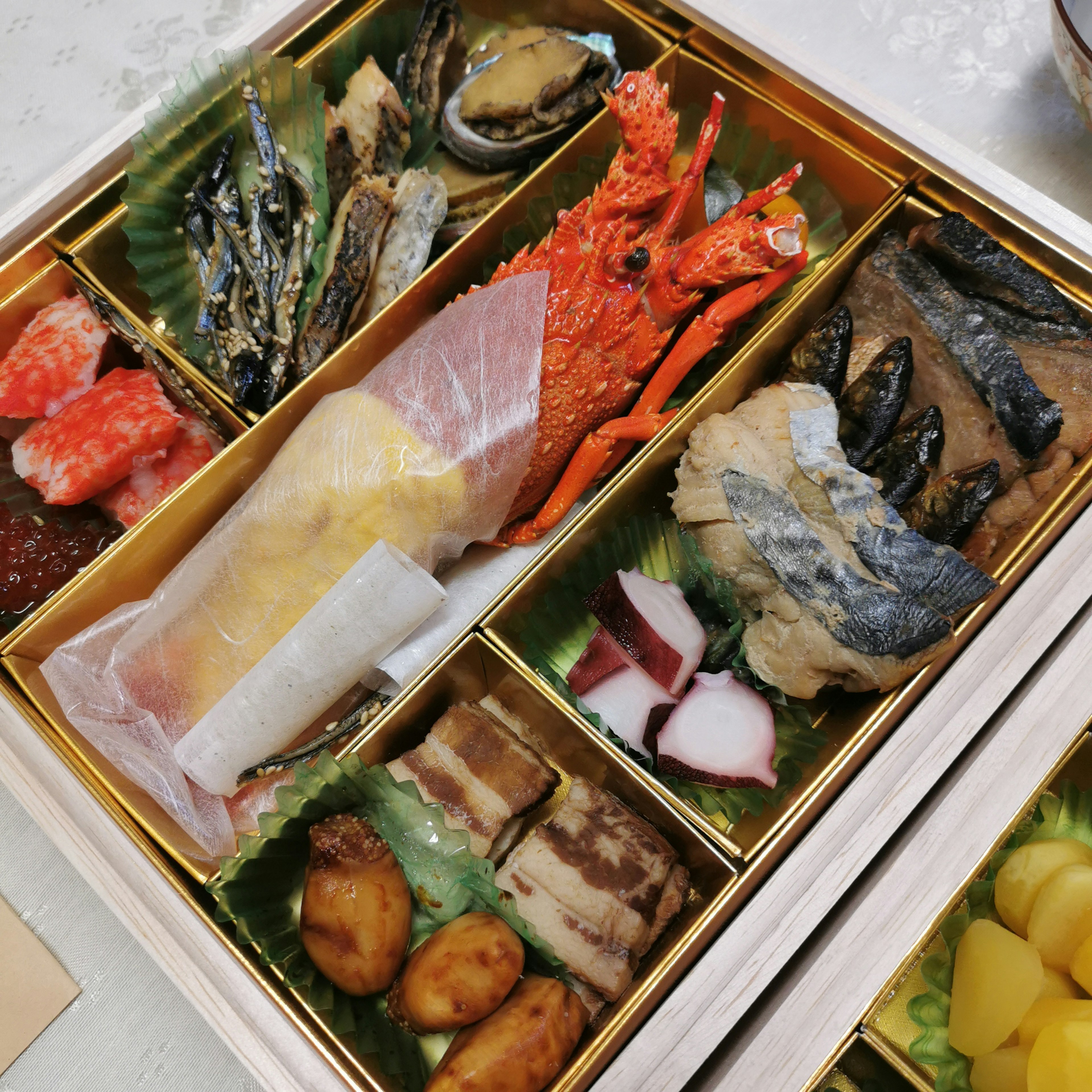 Hidangan Jepang mewah yang menampilkan makanan laut dan hidangan osechi tradisional yang disusun dengan indah