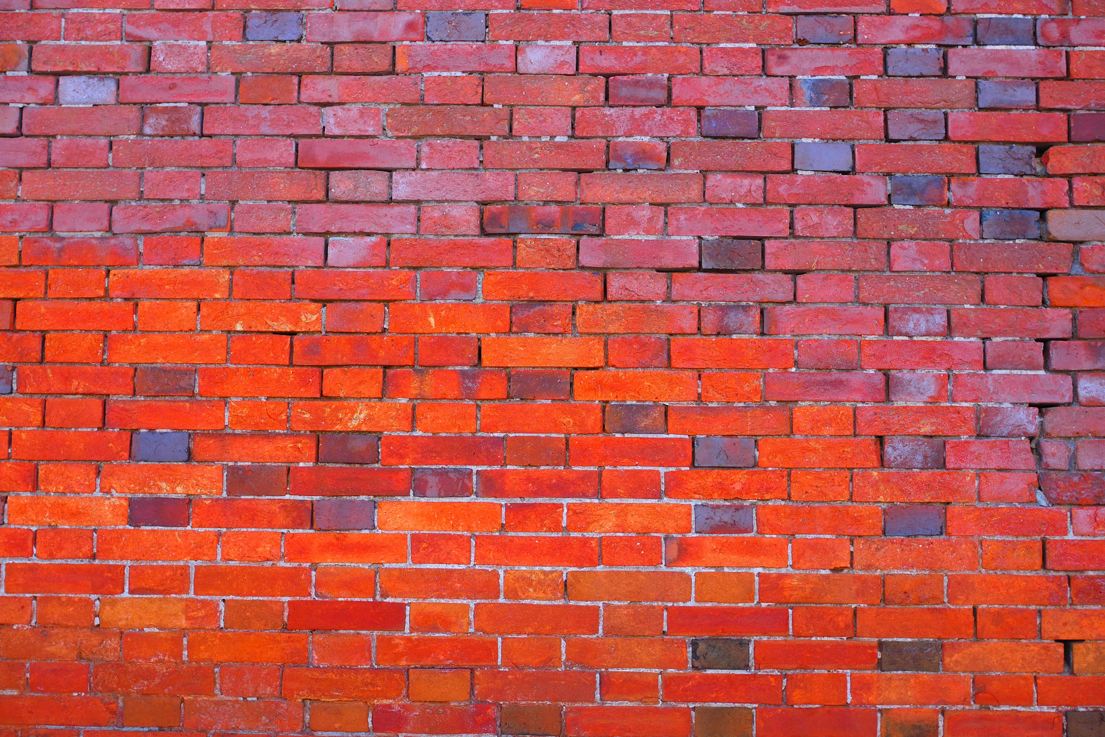 Pared de ladrillos rojos con texturas y tonos variados