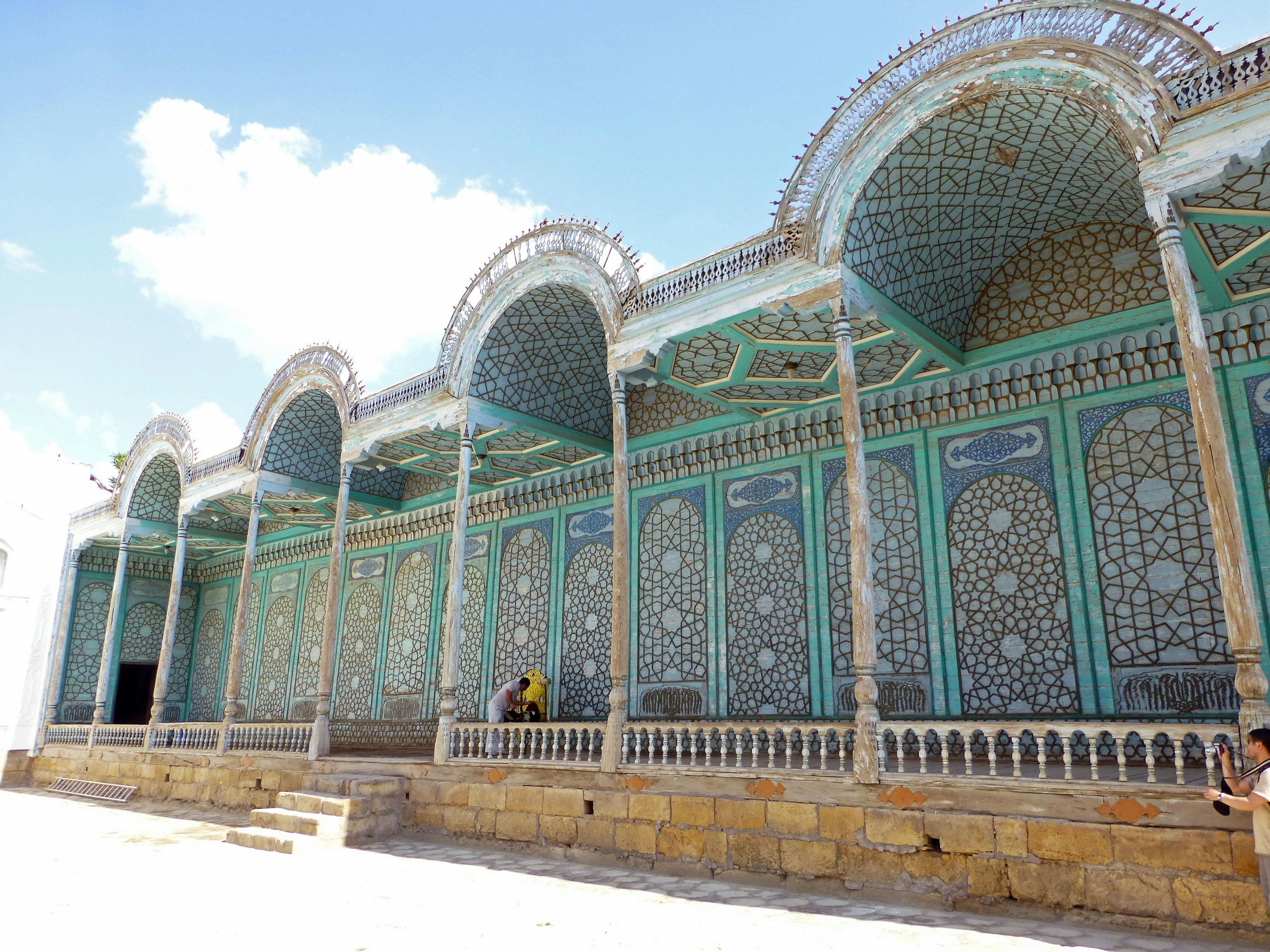 Exterior de un edificio histórico con paredes decorativas azules y verdes intrincadas