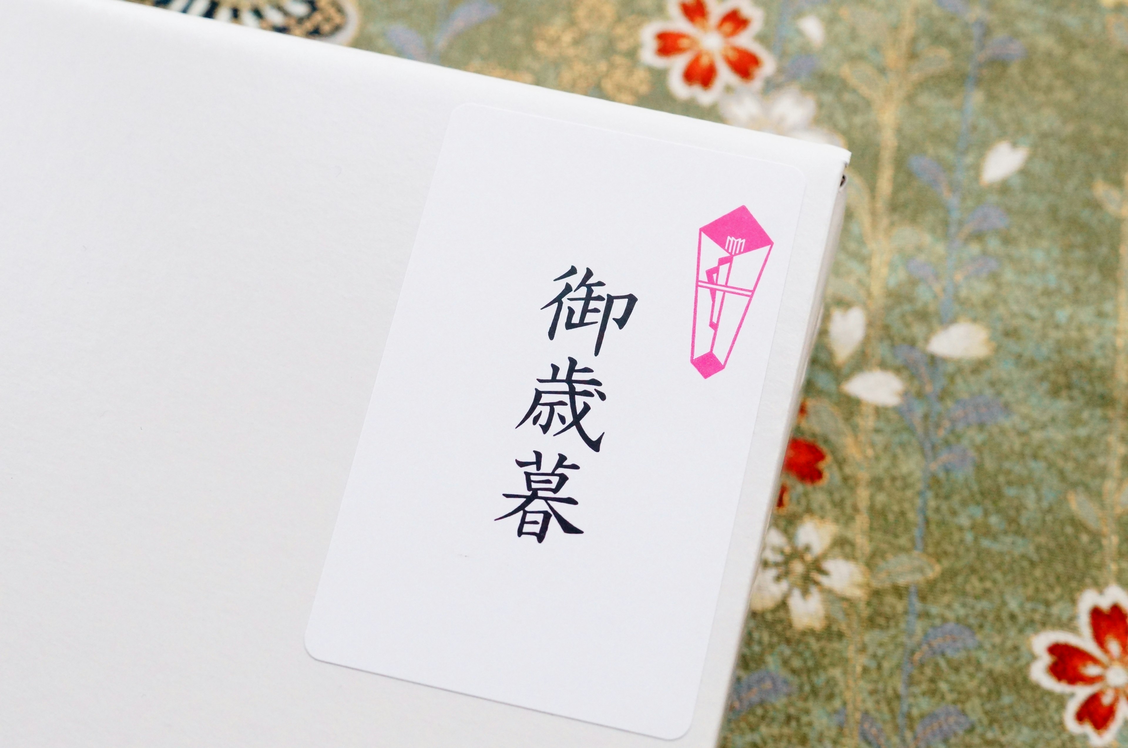 White label with pink decoration reading '御歳暮' on a patterned background