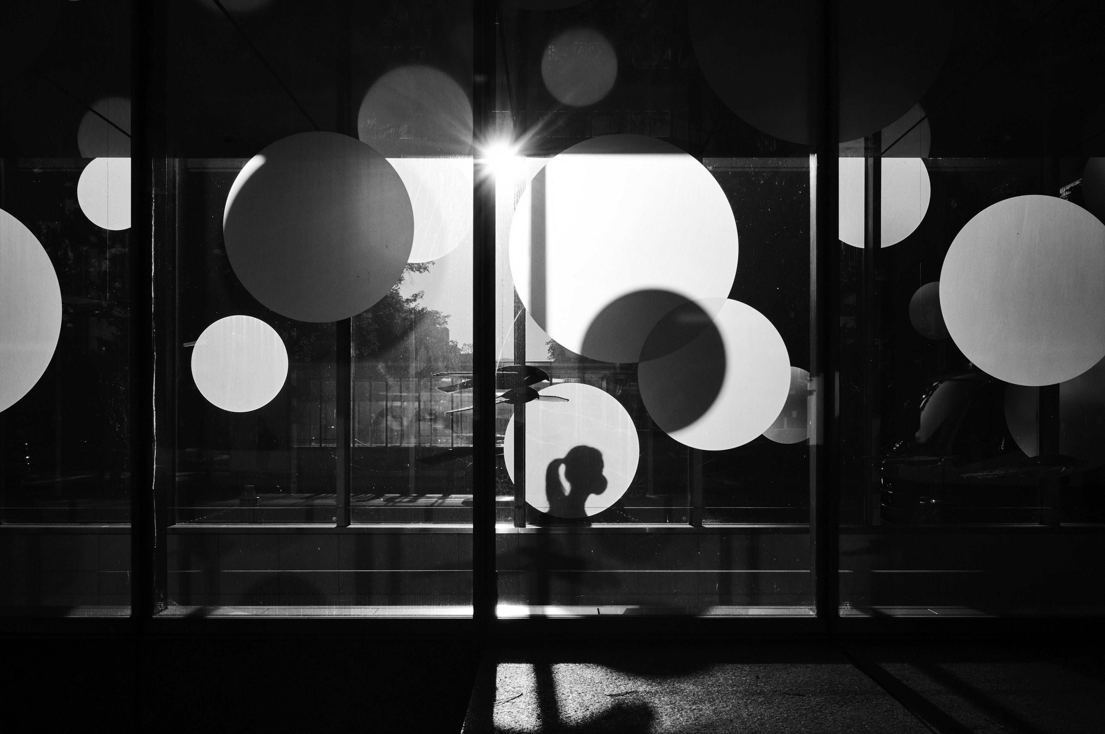 Silhouette of a person against a backdrop of circular decorations in black and white