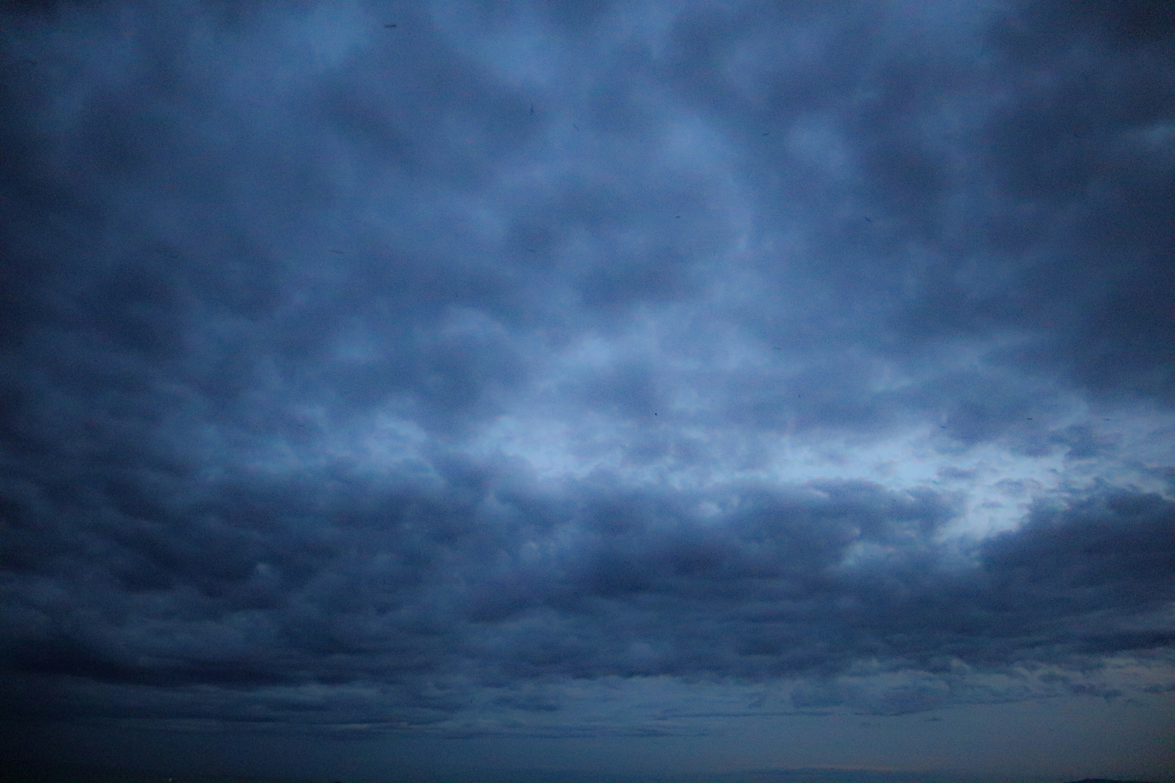 Dark clouds covering the sky with a hint of light