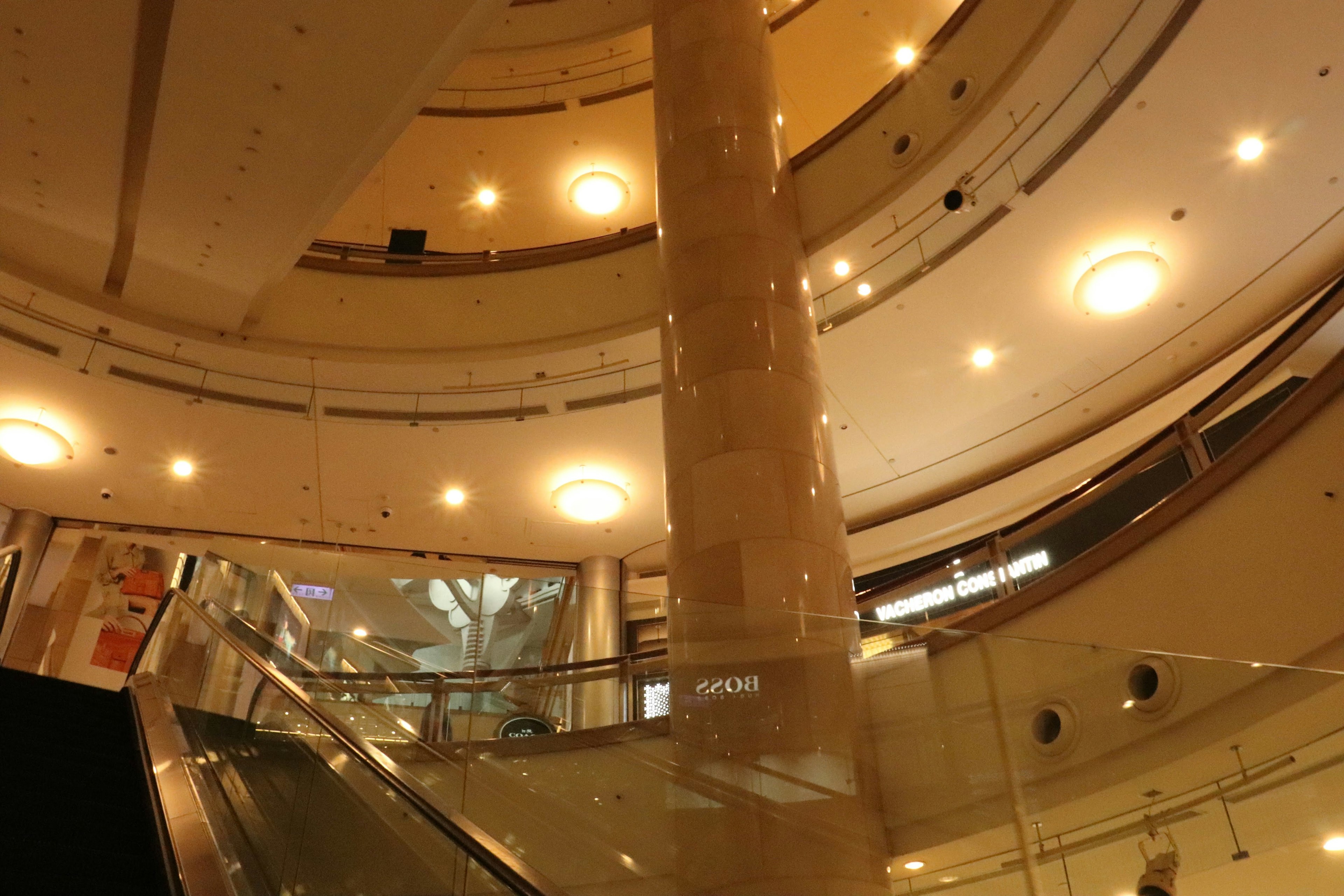 Intérieur d'un centre commercial moderne avec des colonnes en verre et en marbre et un éclairage doux