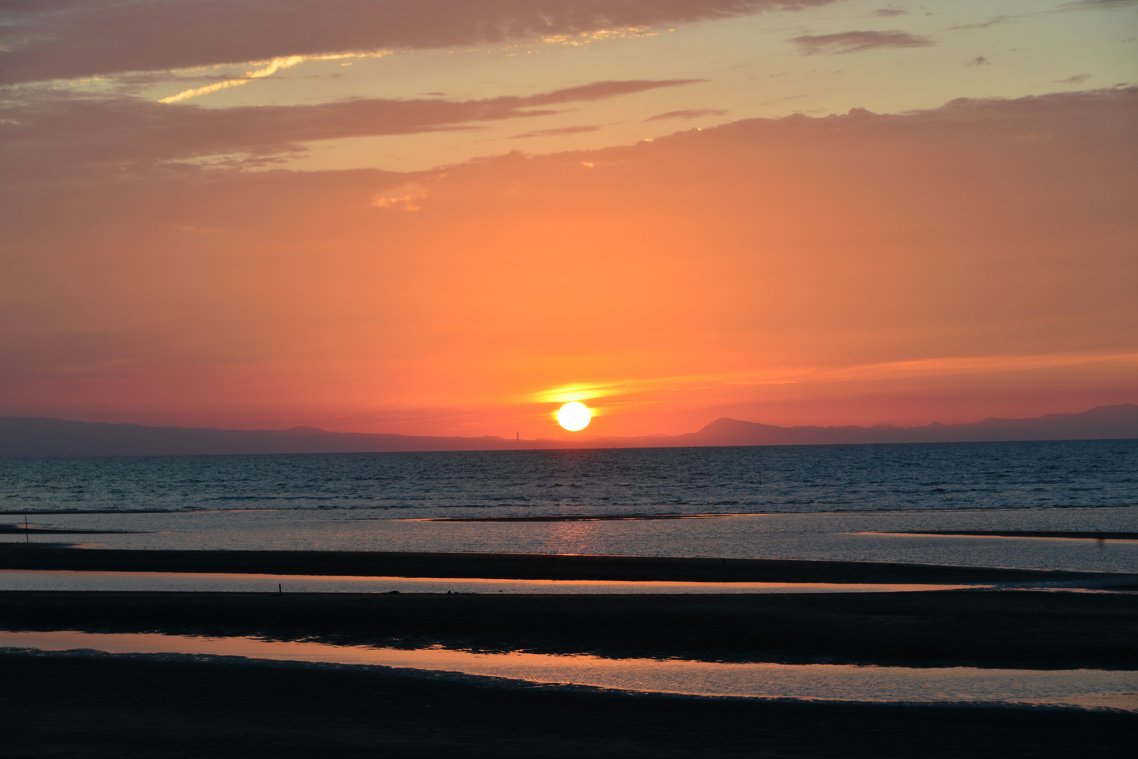 Wunderschöner Sonnenuntergang über dem Ozean mit sanften Wellen