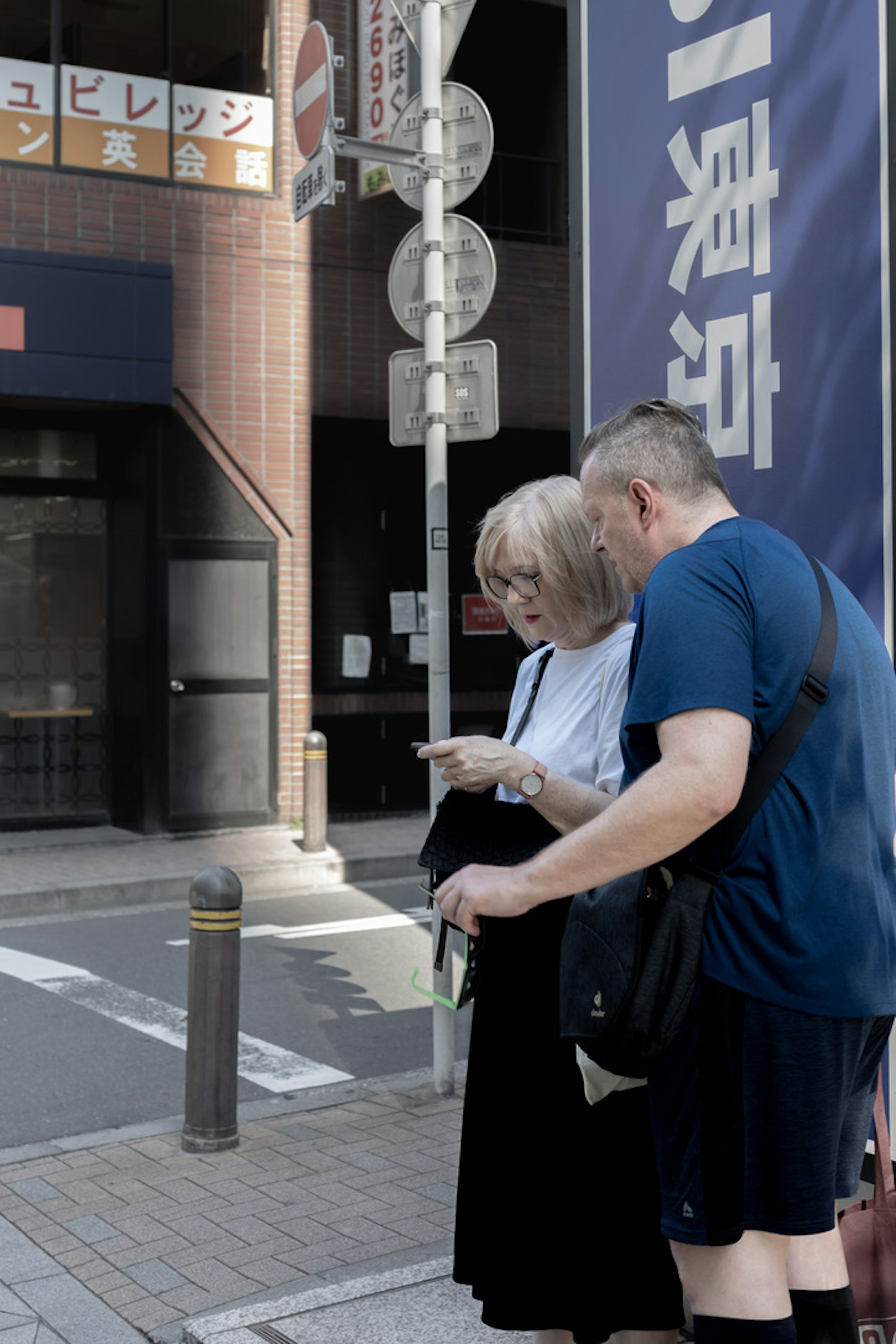 Two people looking at a map while crossing the street