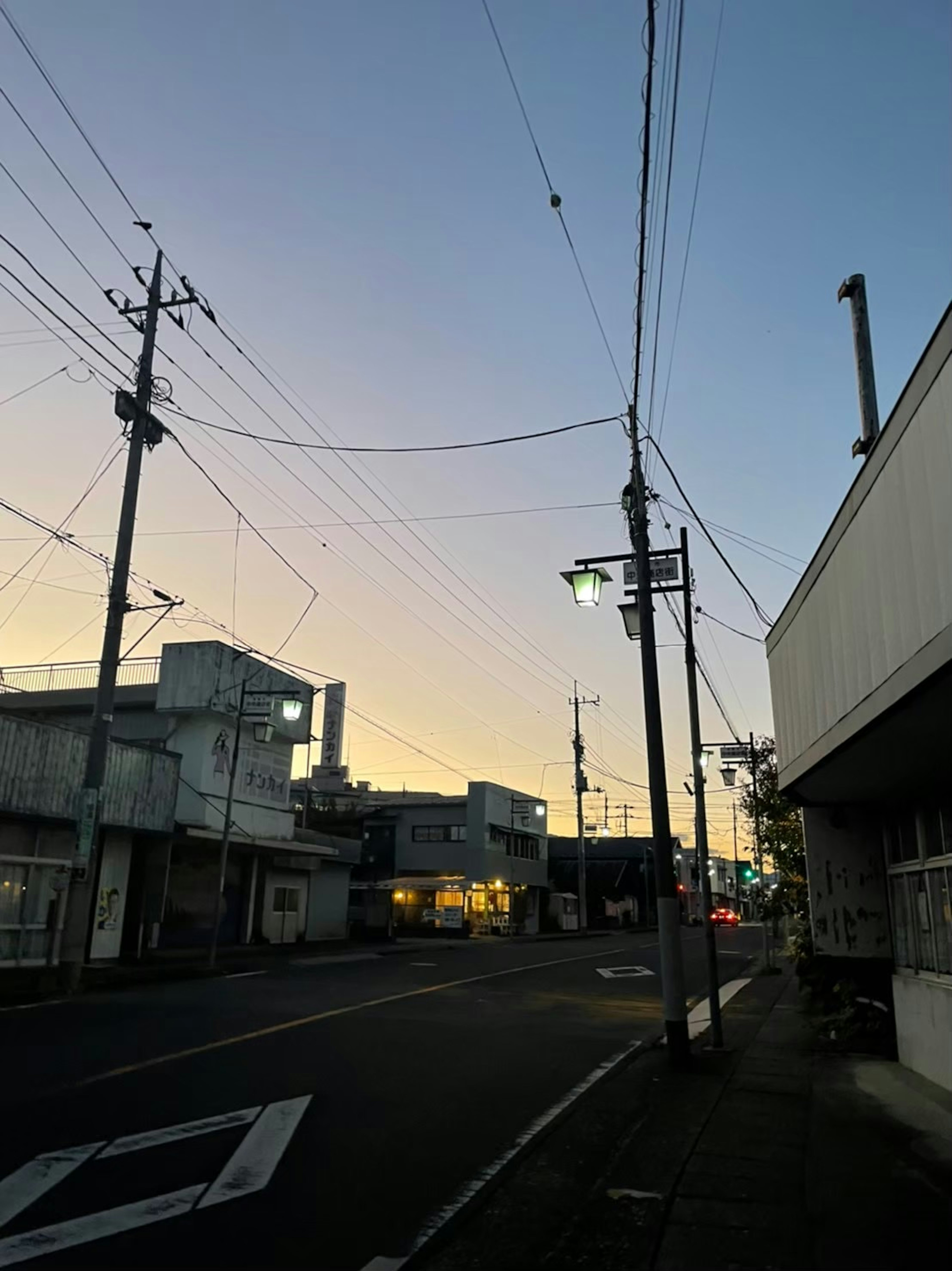 Calle tranquila al anochecer con postes de luz y edificios