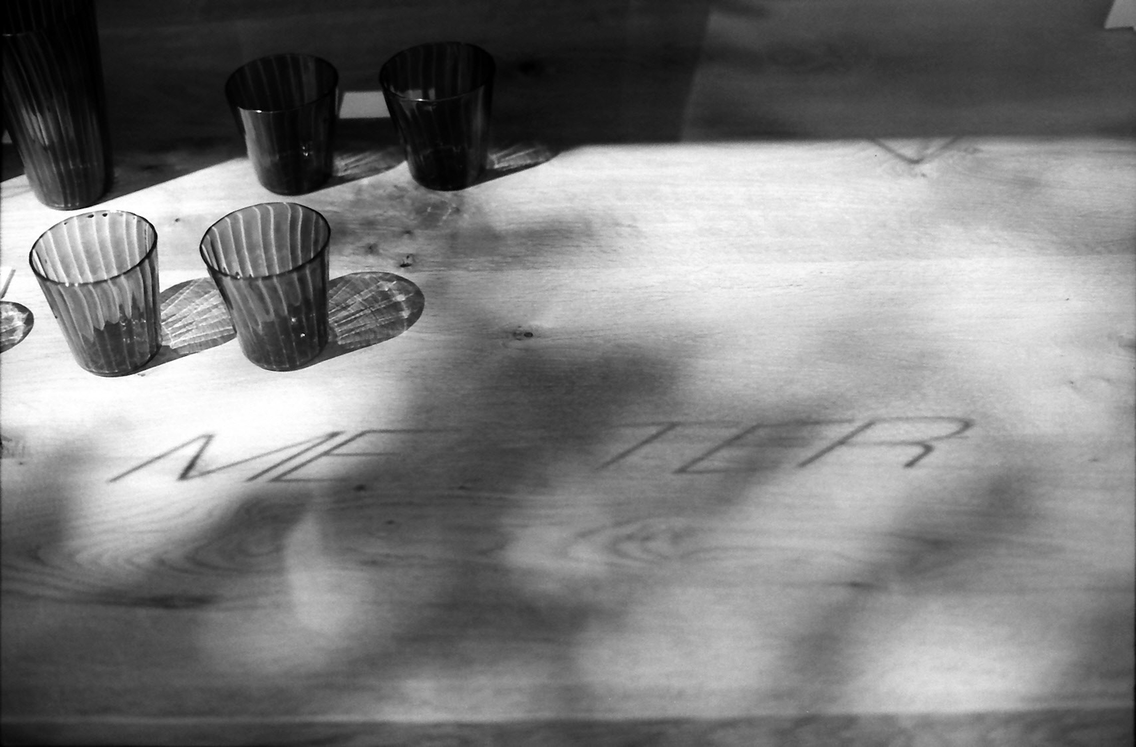 Wooden table with engraved text and clear cups