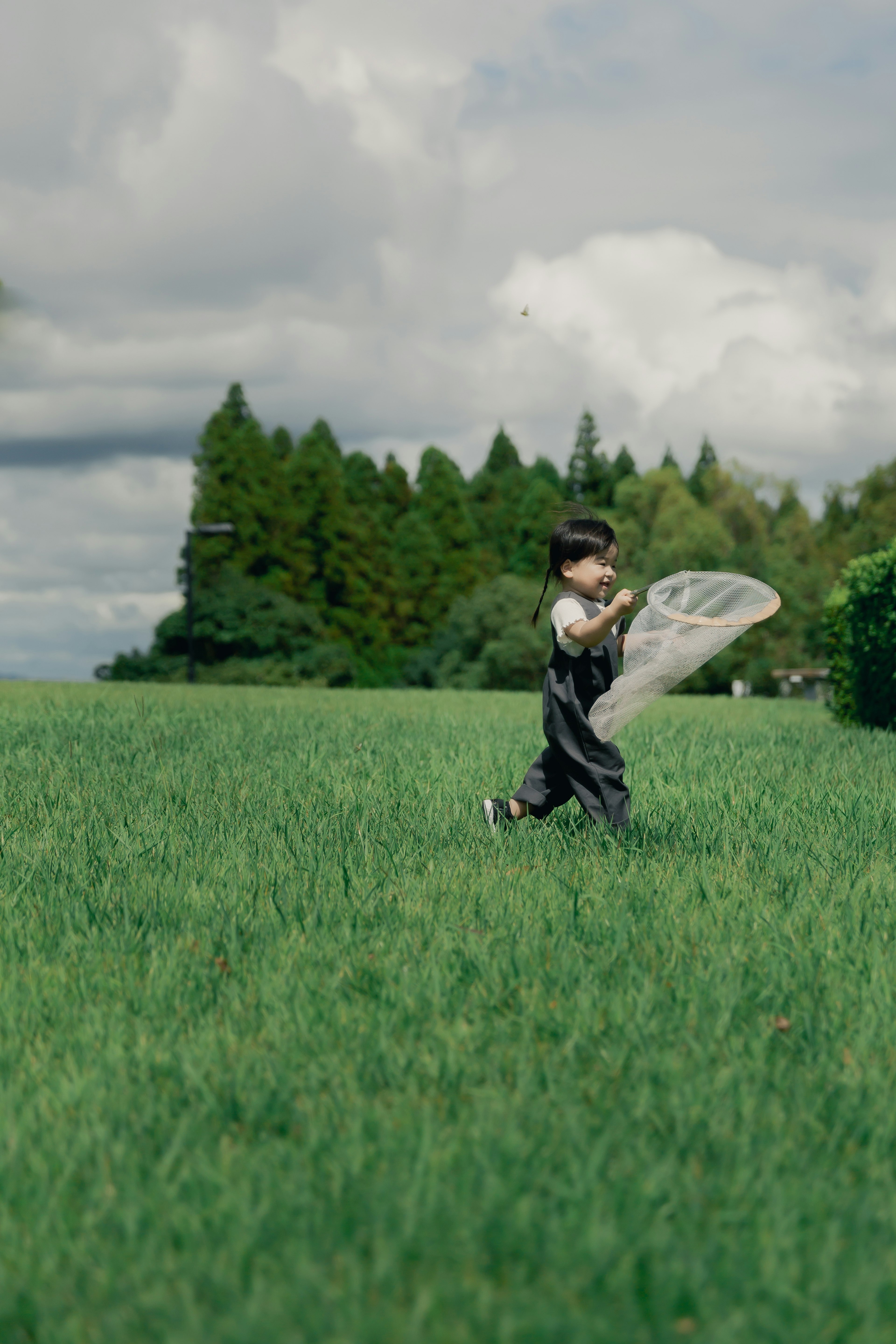 A child running in a grassy field with a net