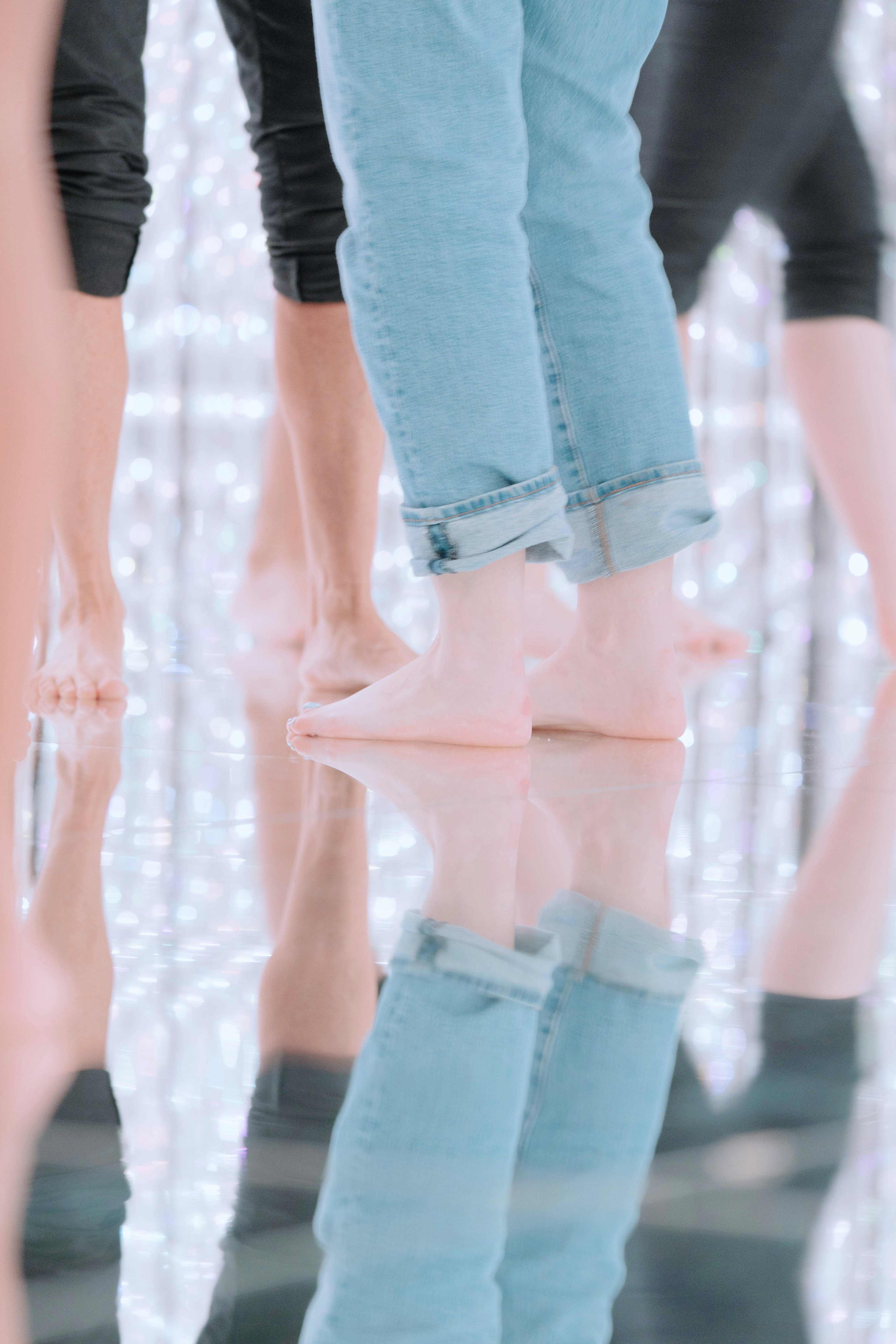 Image featuring people's feet with mirror-like reflection