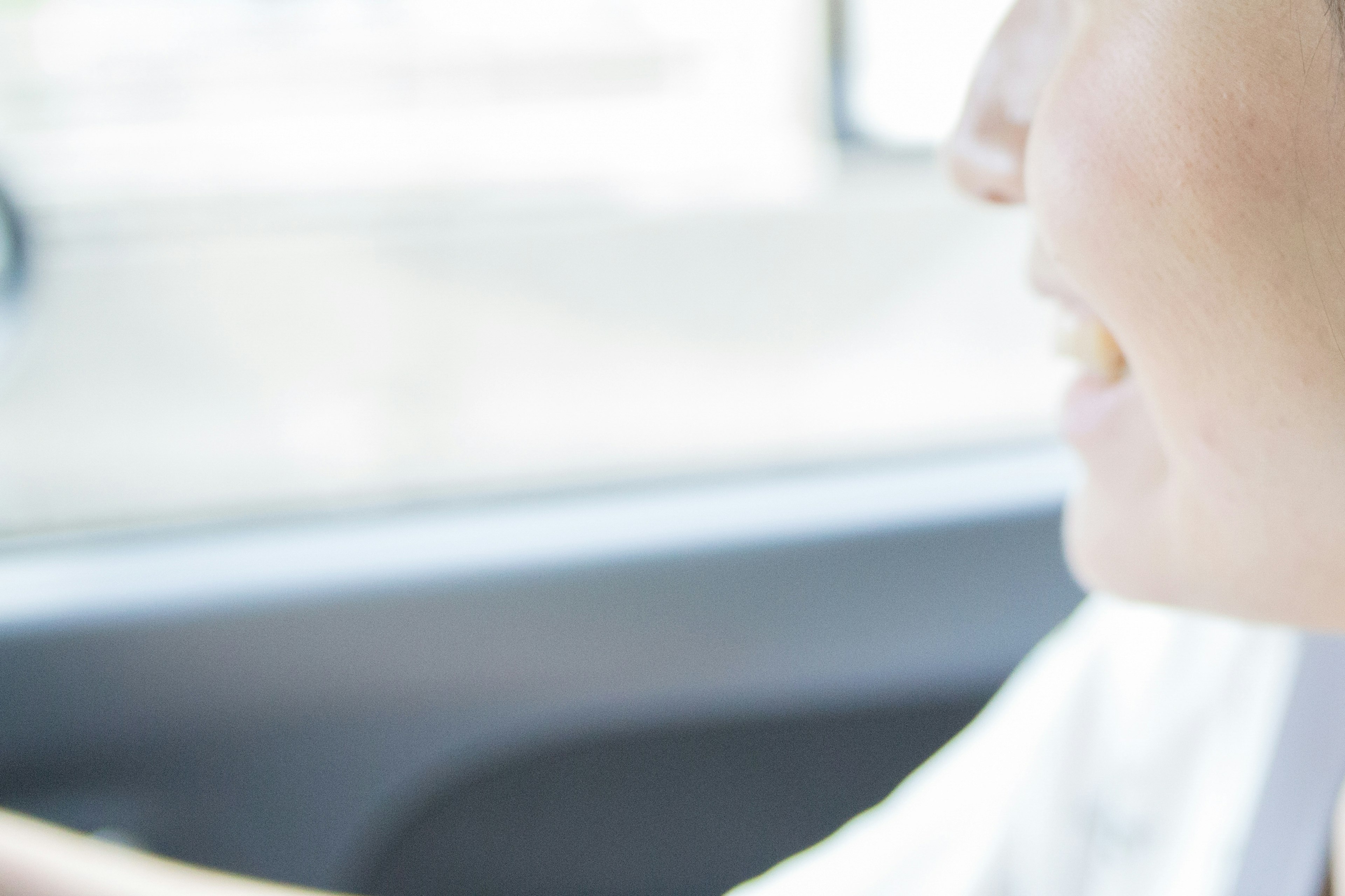 Close-up of a smiling woman's profile while driving in a car