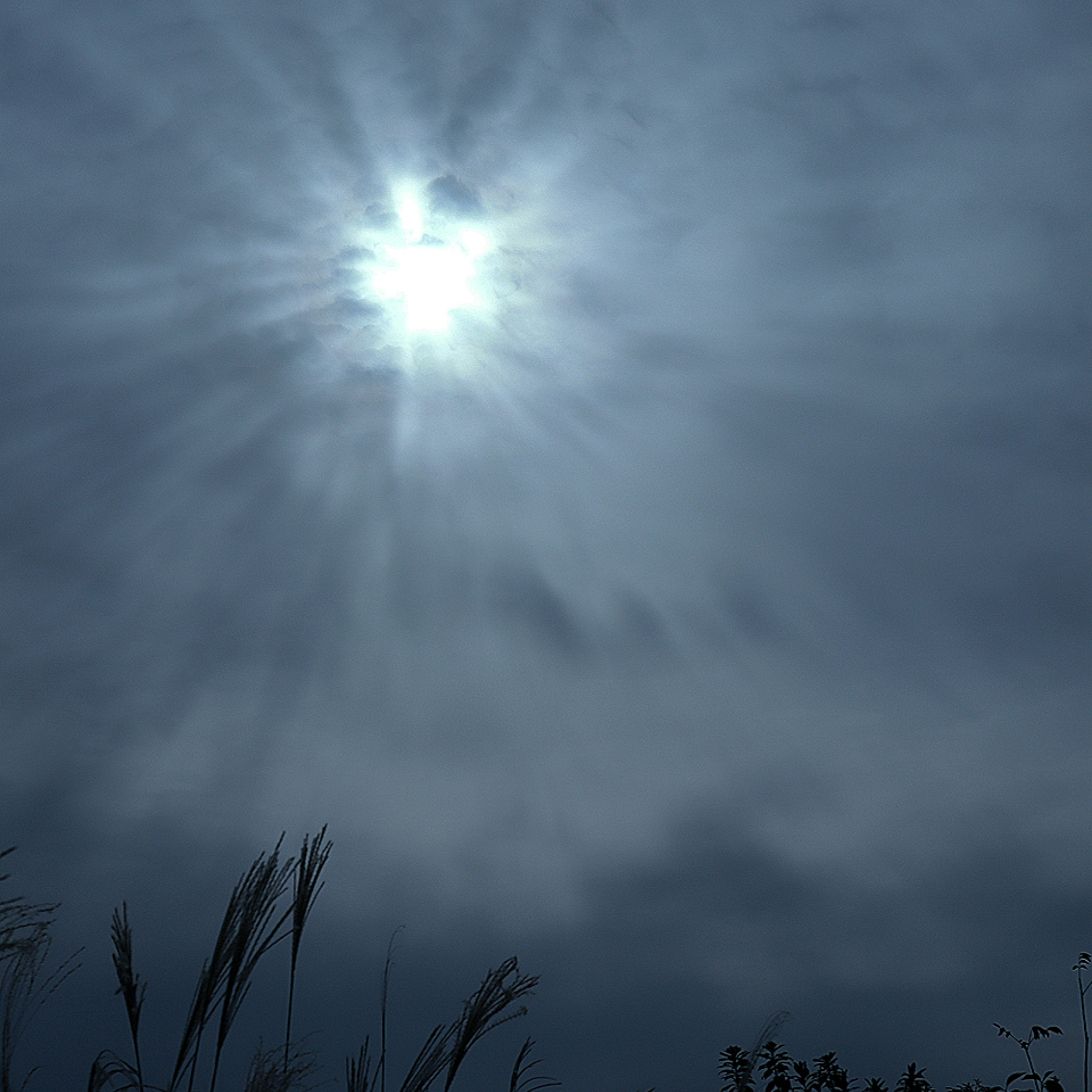 雲に覆われた空に輝く太陽の光と影のコントラスト