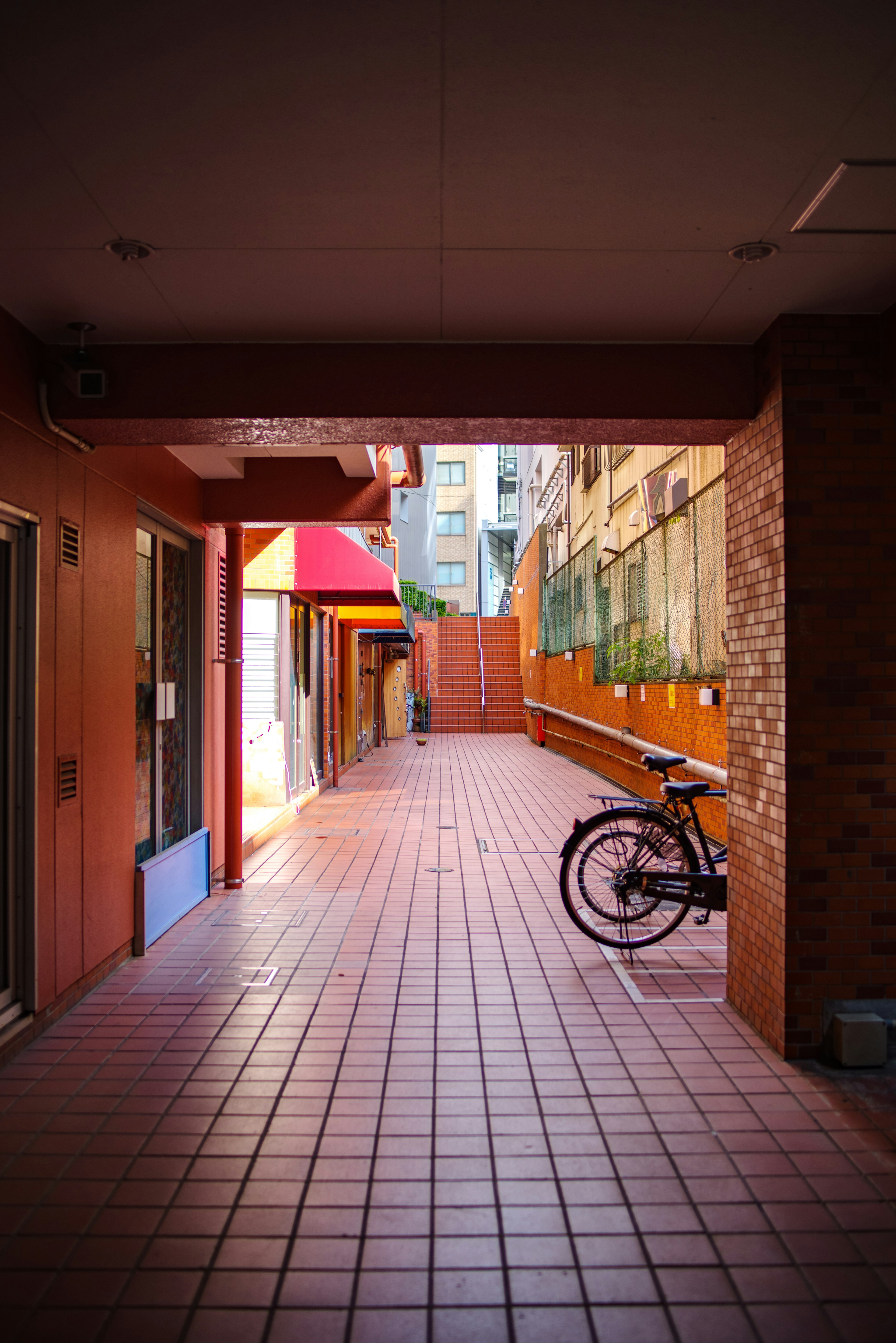 A corridor with red walls and tiles featuring a bicycle