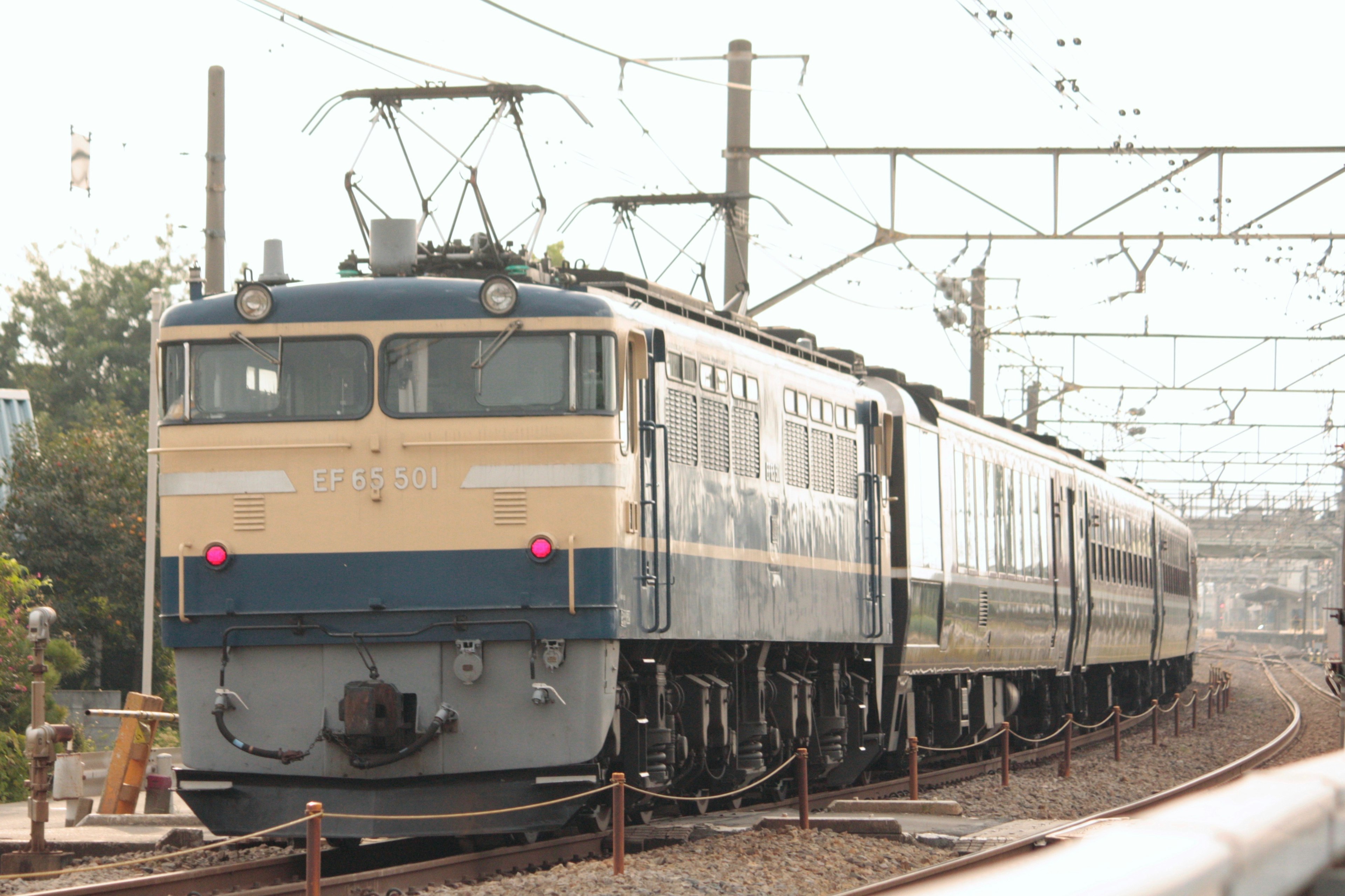 Kereta listrik biru dan putih berhenti di rel