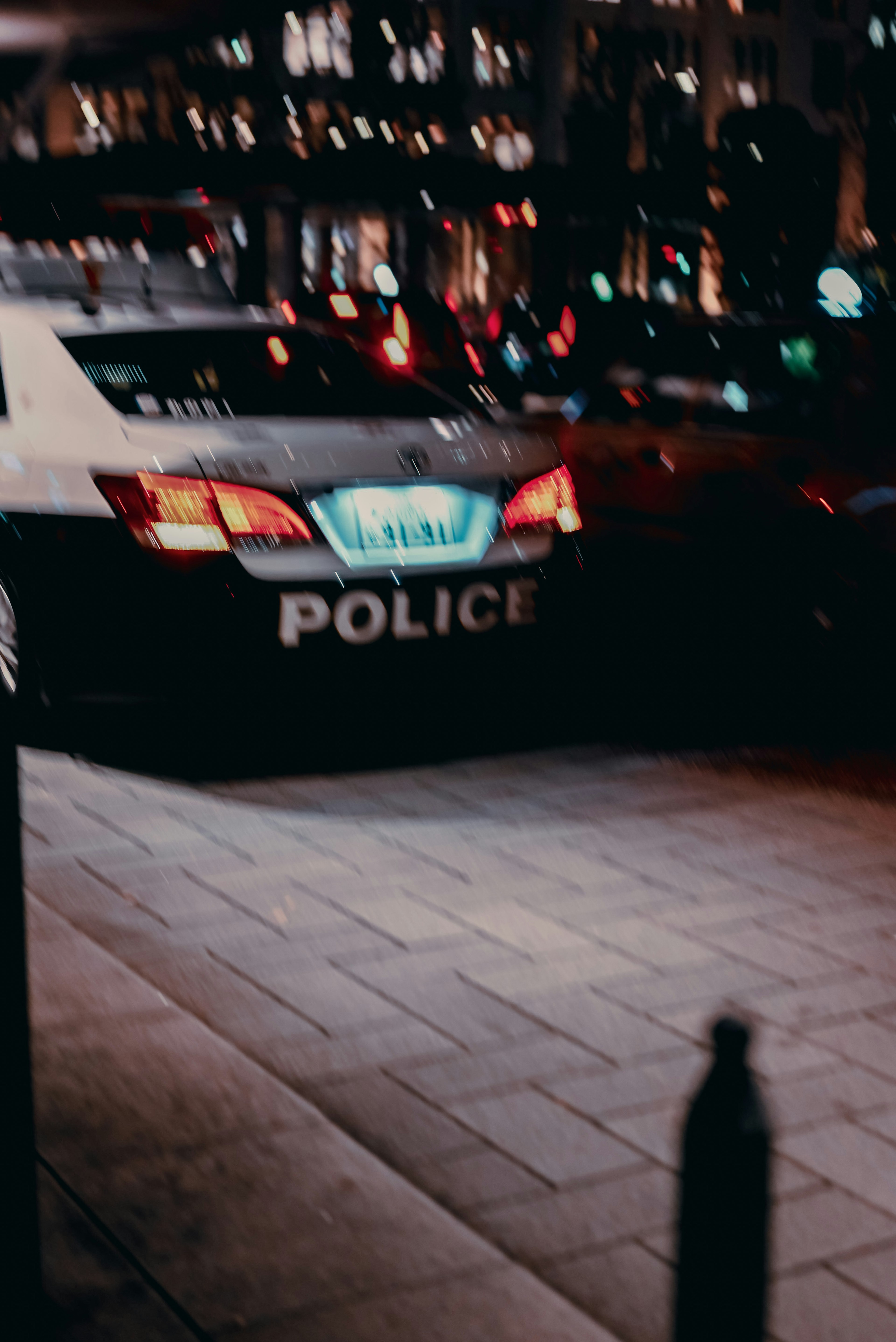 A police car parked in the city at night with illuminated lights