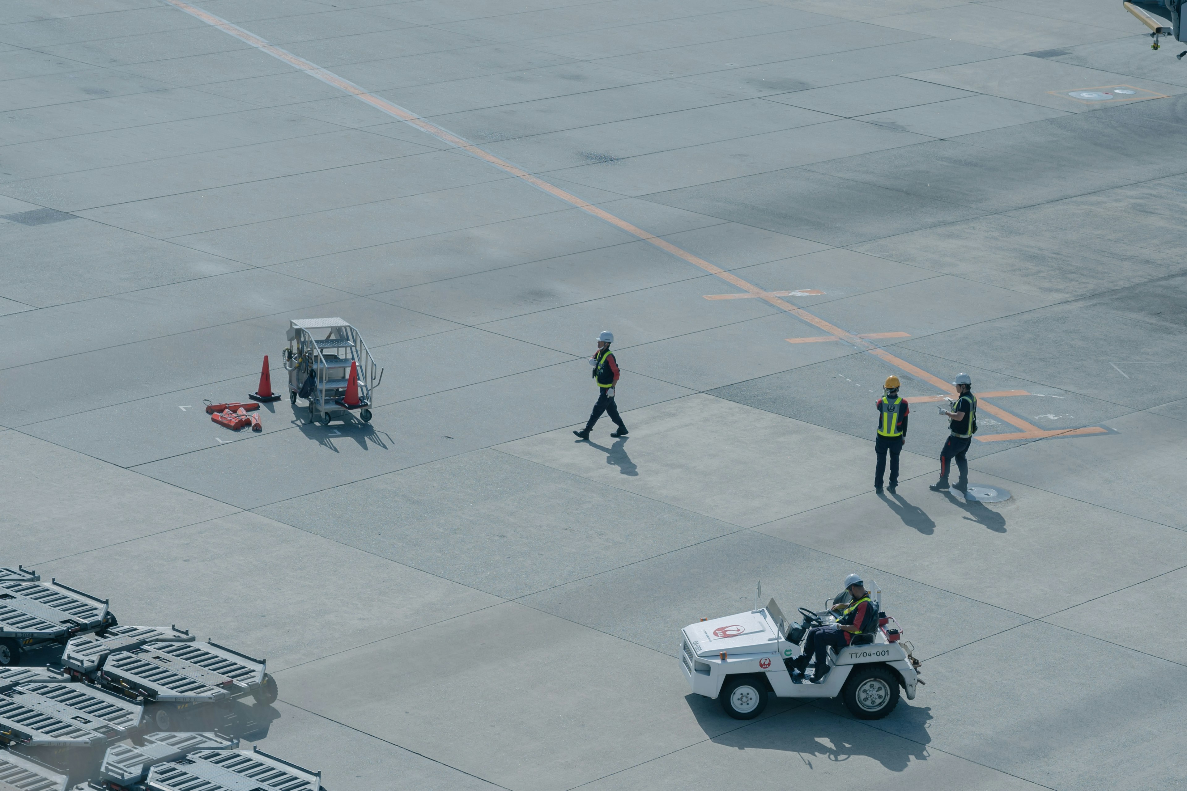 Escena de pista de aeropuerto con personal y vehículos