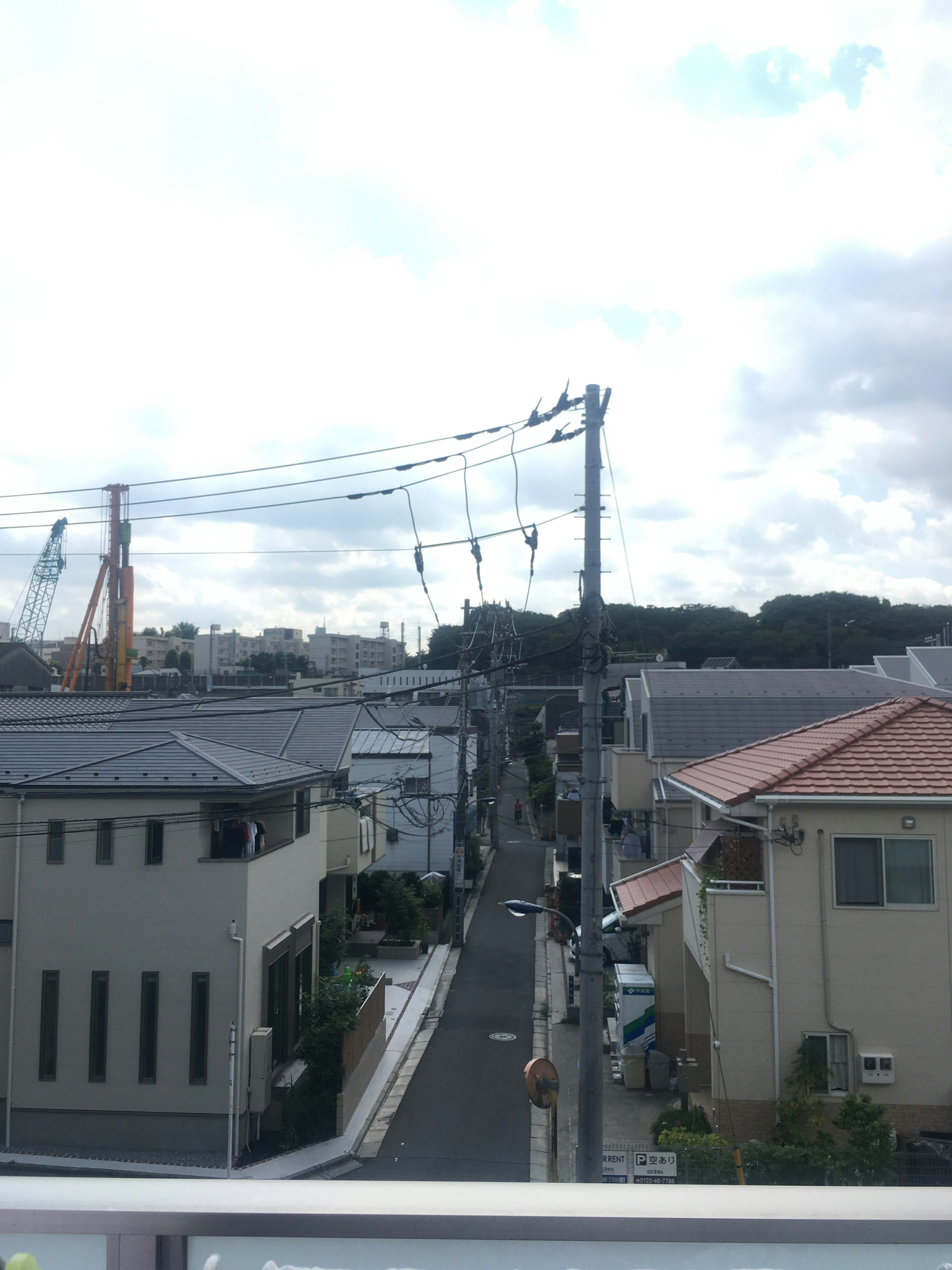 Residential neighborhood with telephone poles and cloudy sky