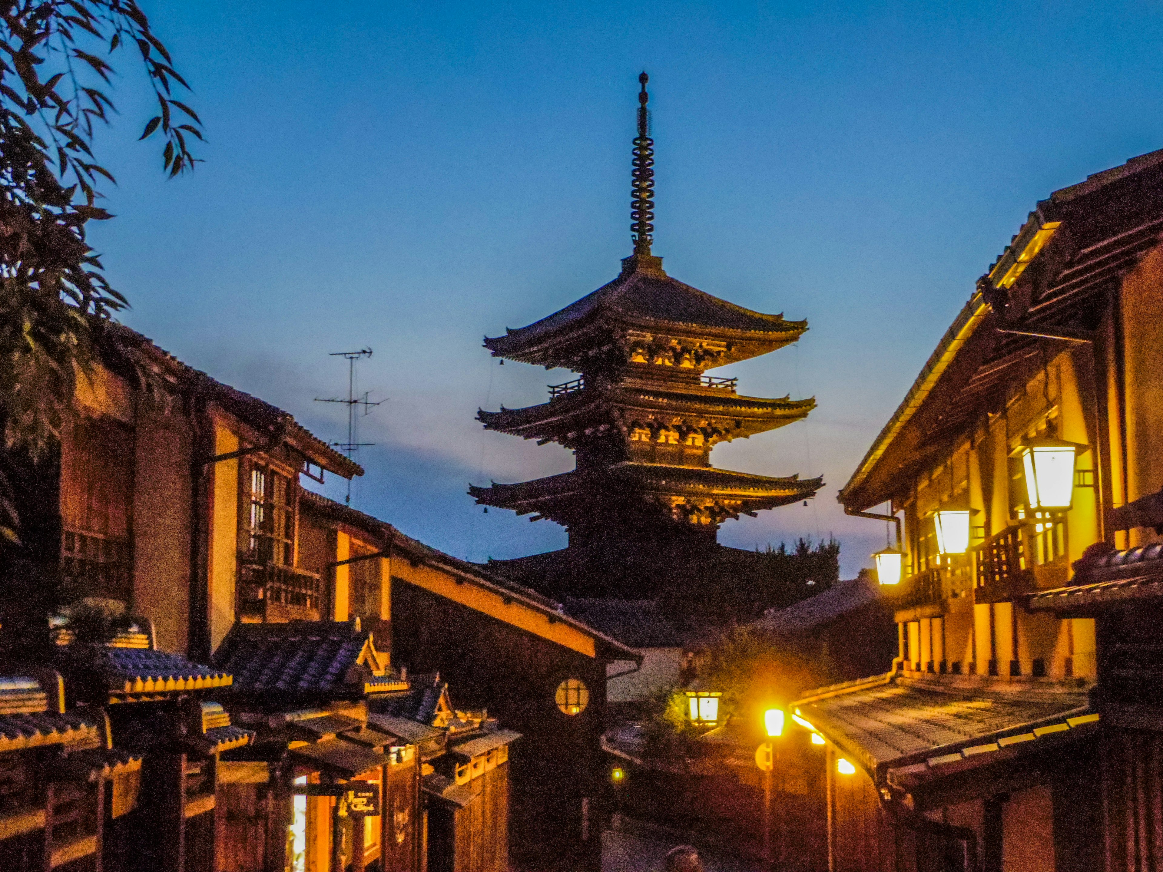 Calle de Kioto al anochecer con una pagoda y edificios de madera tradicionales