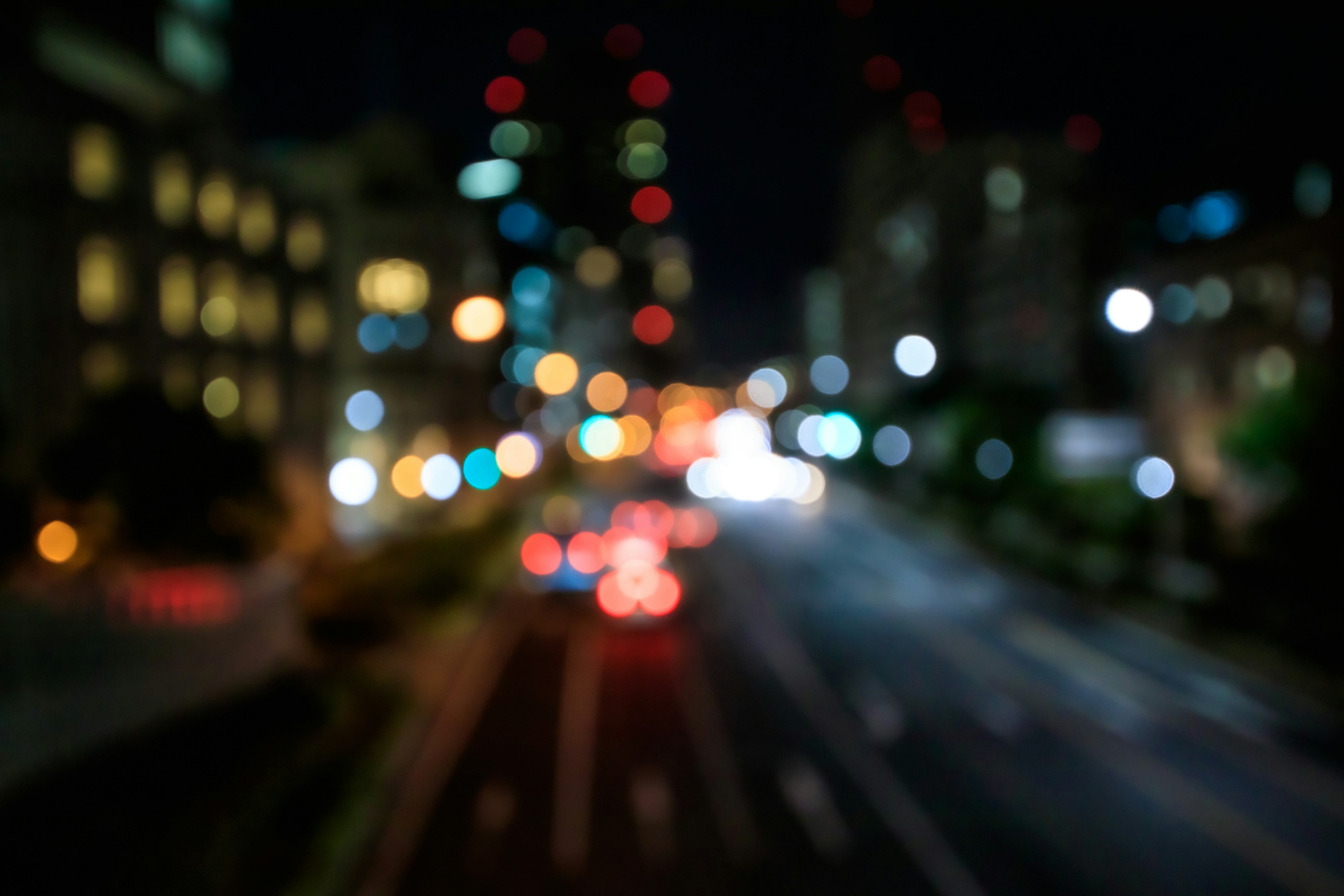 Blurred night cityscape with car lights and building lights visible