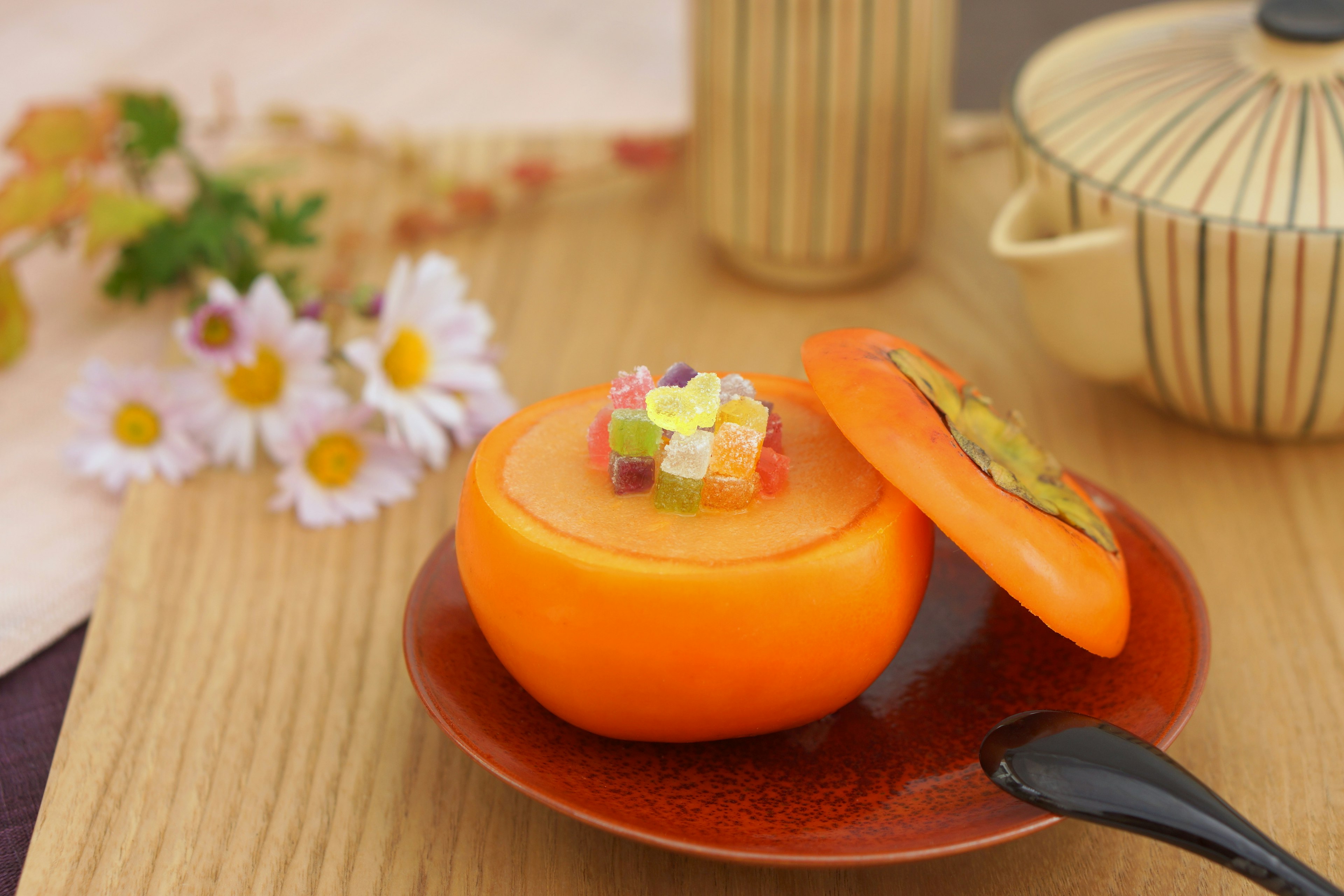 Un postre hecho de un caqui naranja lleno de coberturas coloridas