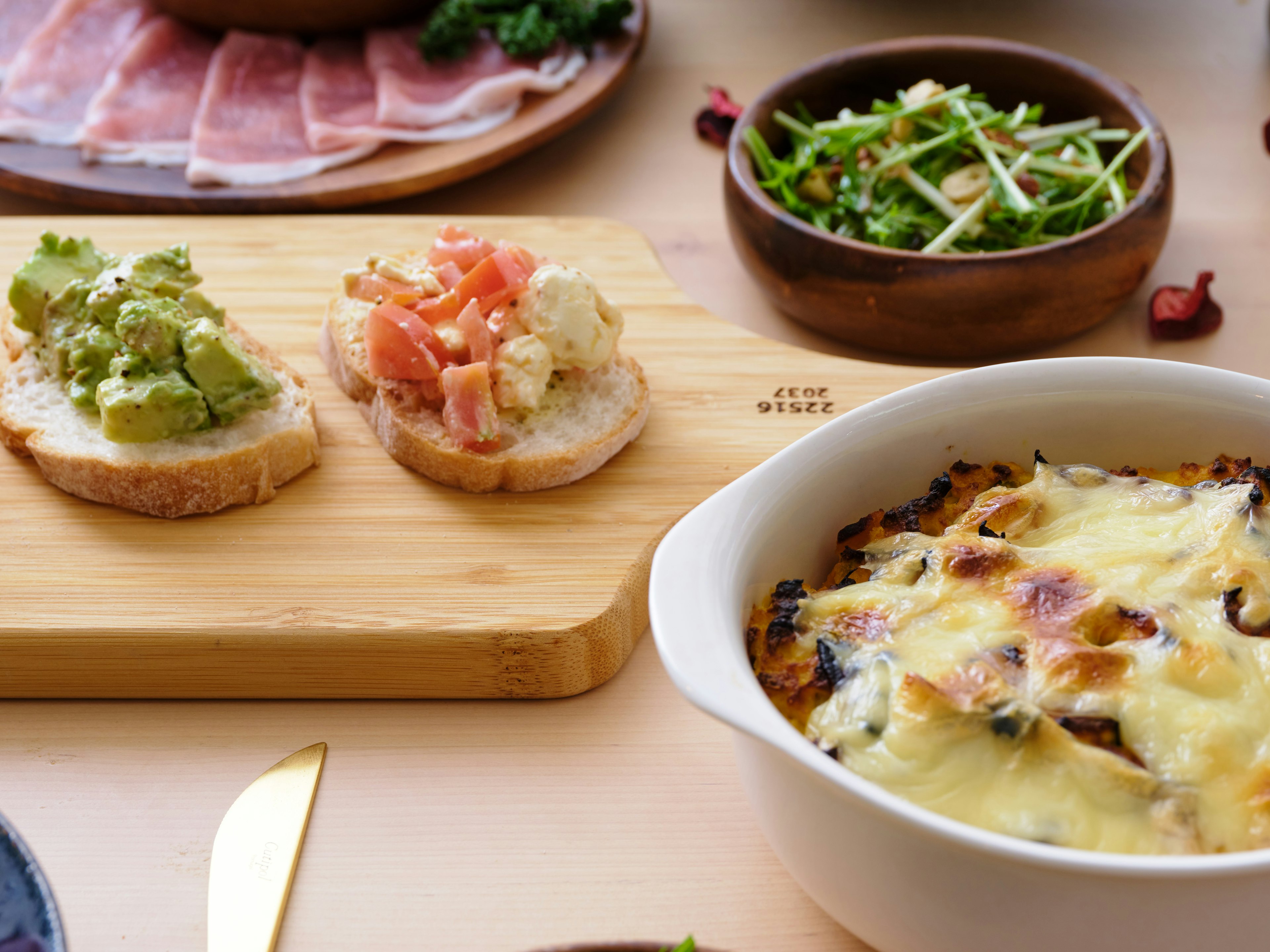 A scene featuring toasted bread topped with avocado and tomato garnishes