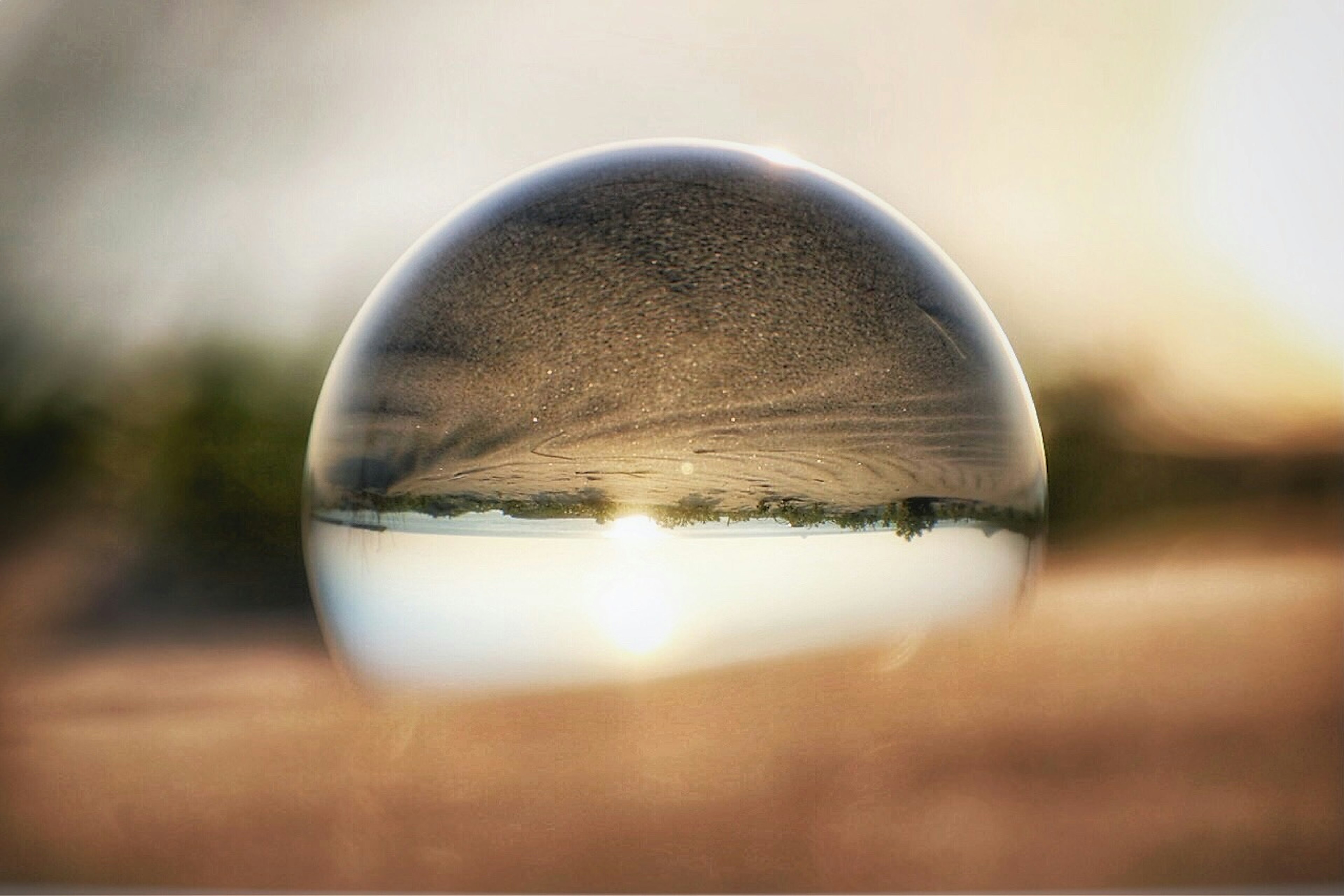 Bolla di cristallo che riflette il tramonto e il paesaggio