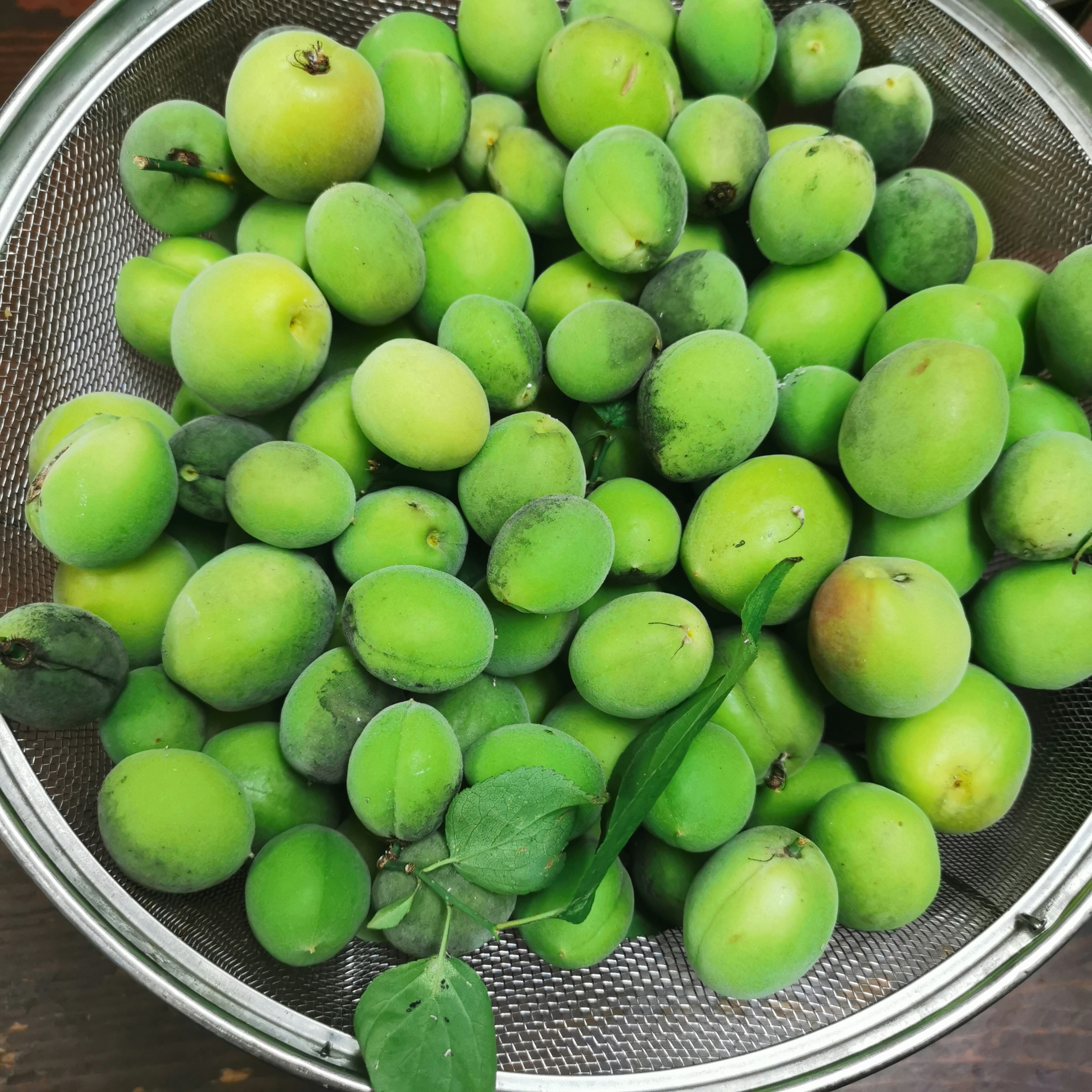 Un égouttoir rempli d'une abondance de fruits verts