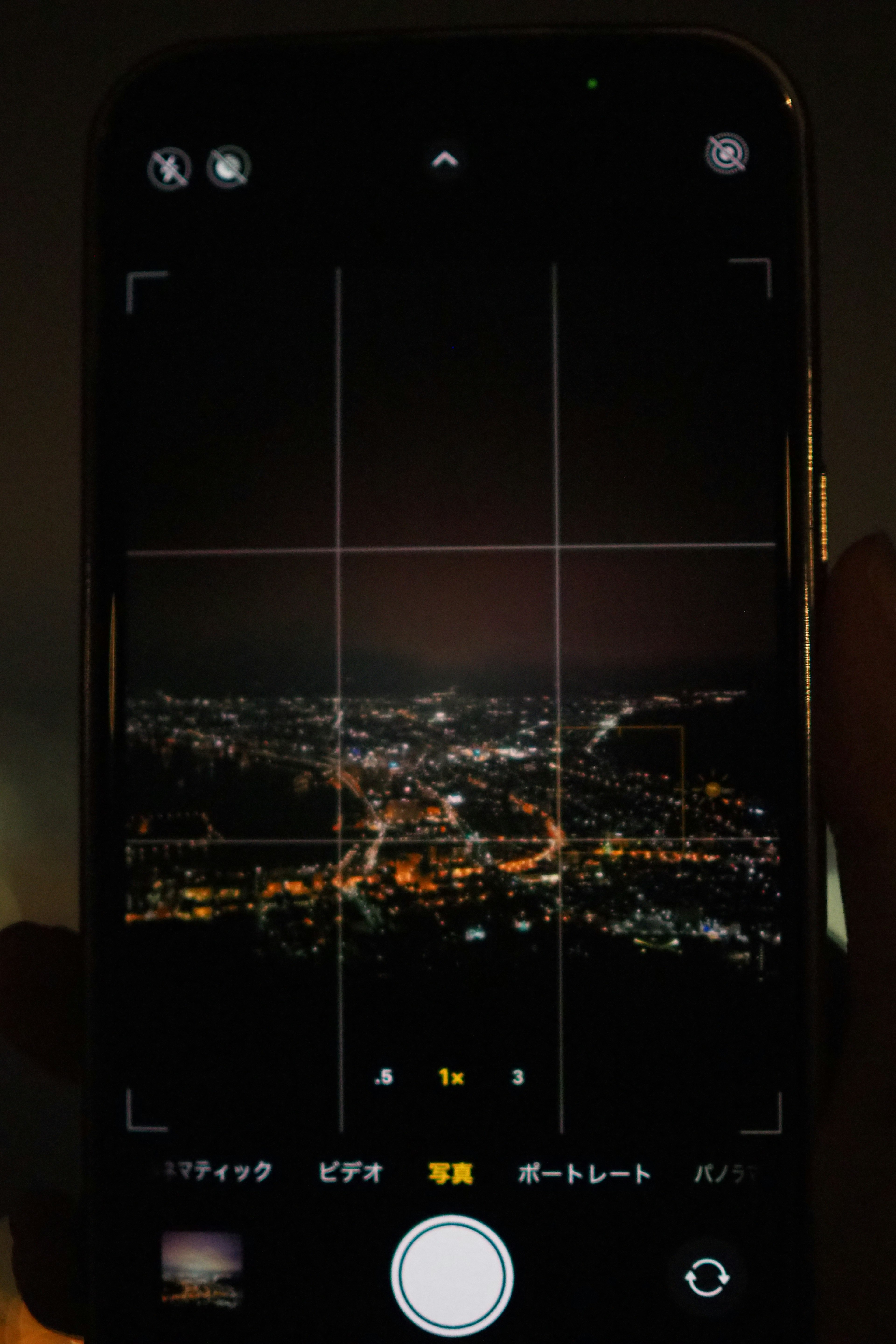 Smartphone camera screen capturing a night view held in hand