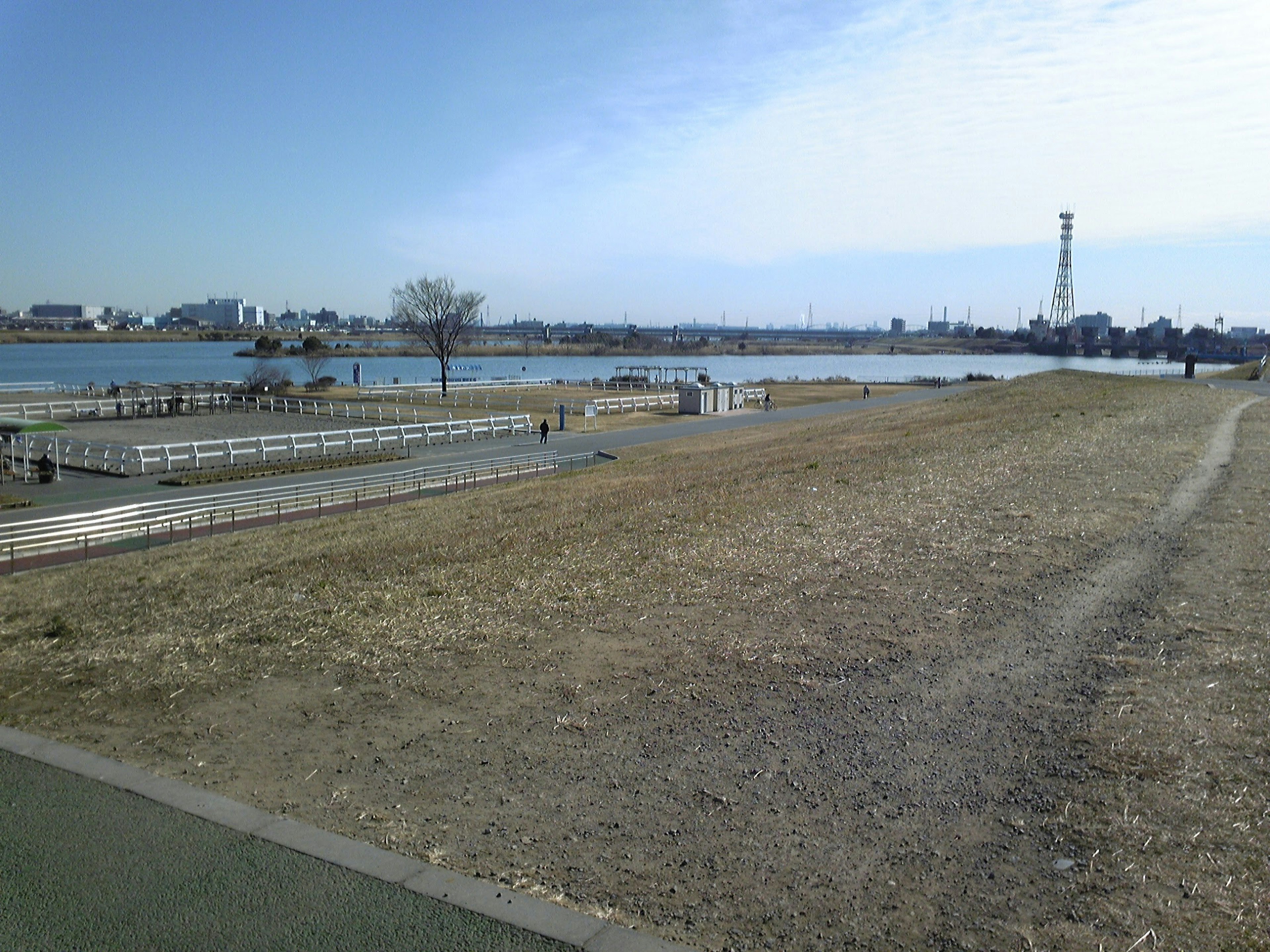 Scenic view of a wide grassy area near a river with a walking path