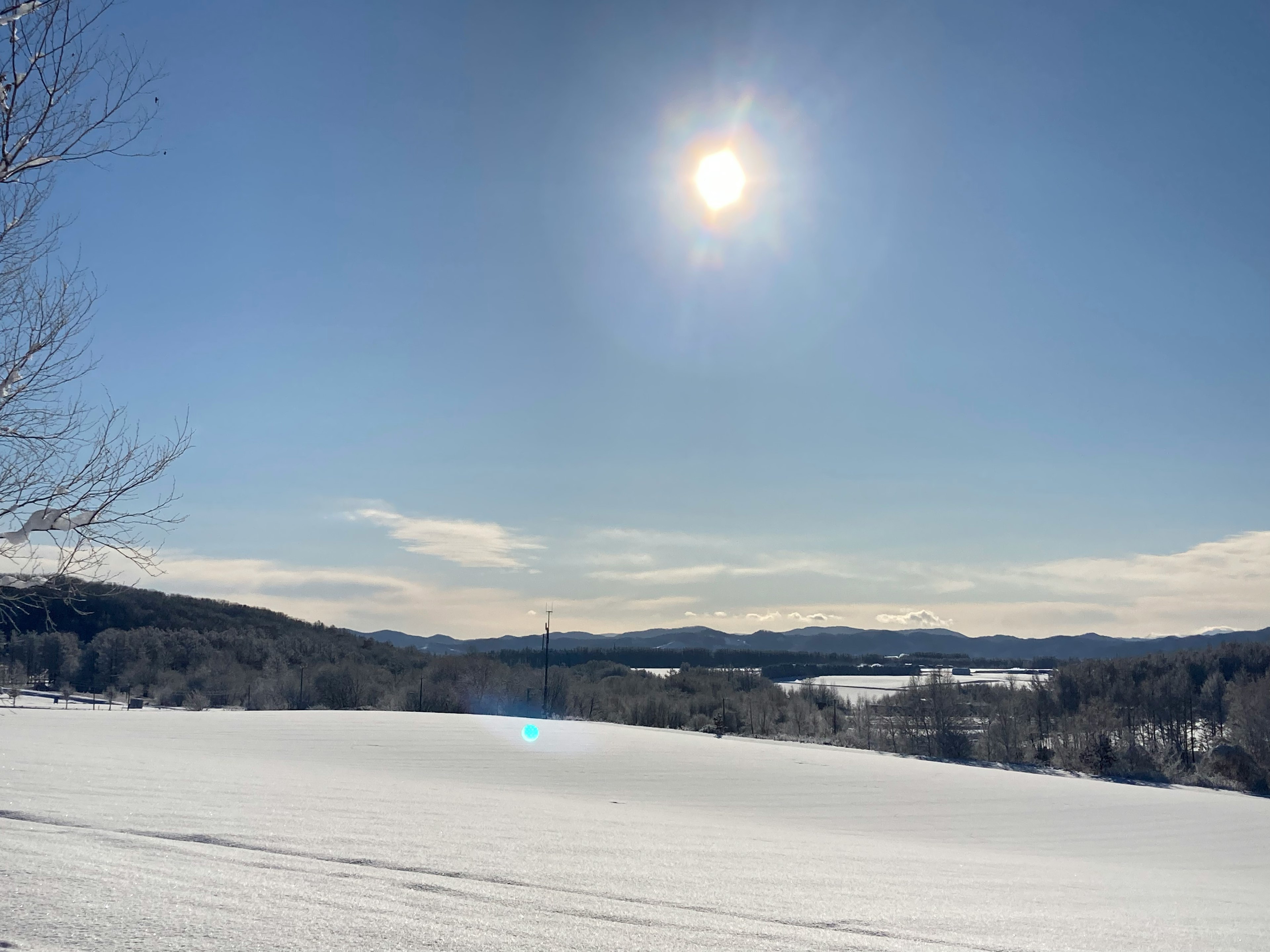 Paysage enneigé sous un ciel bleu avec le soleil