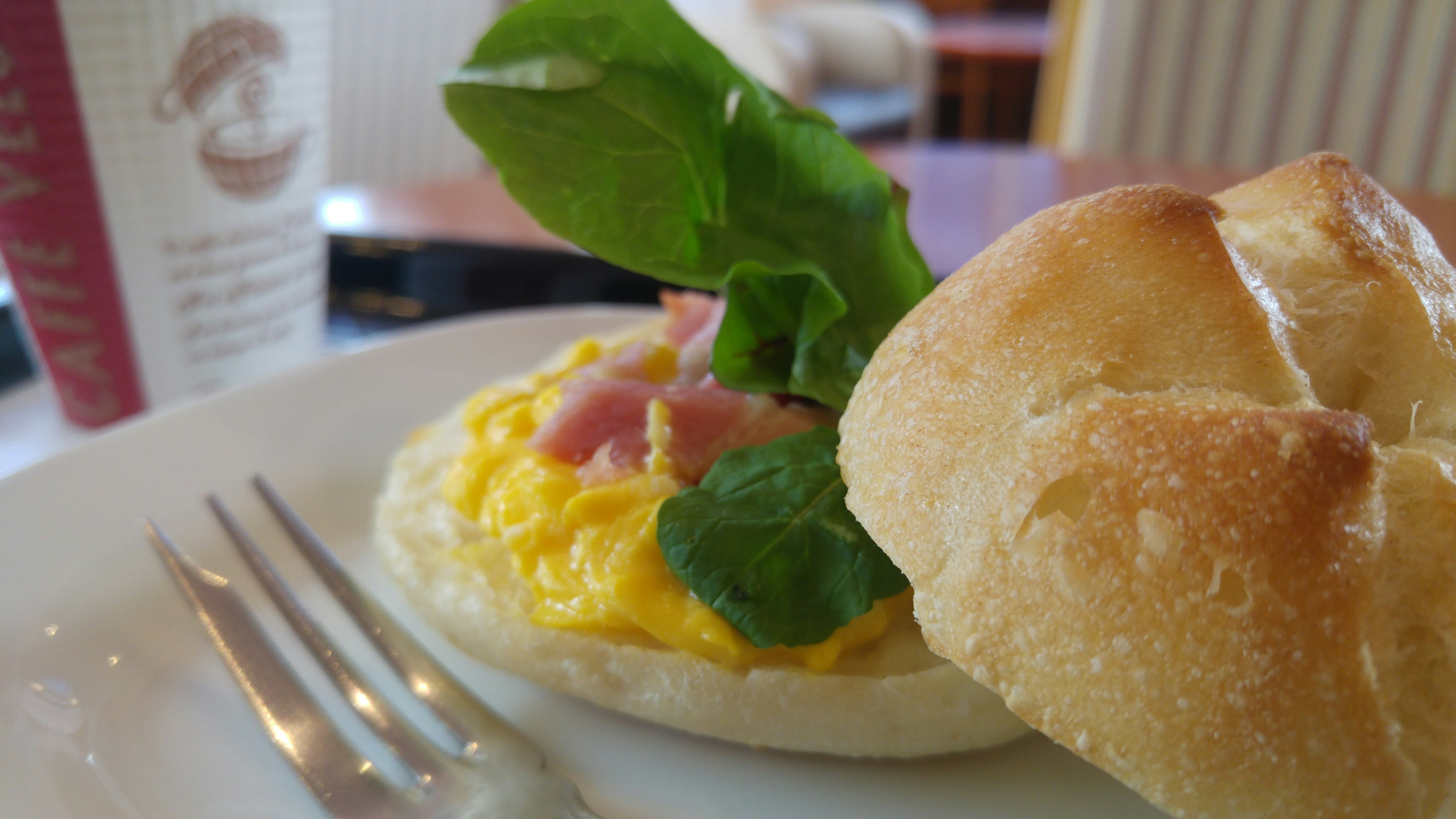 Petit déjeuner délicieux avec une omelette aux œufs jambon et épinards servie avec un petit pain