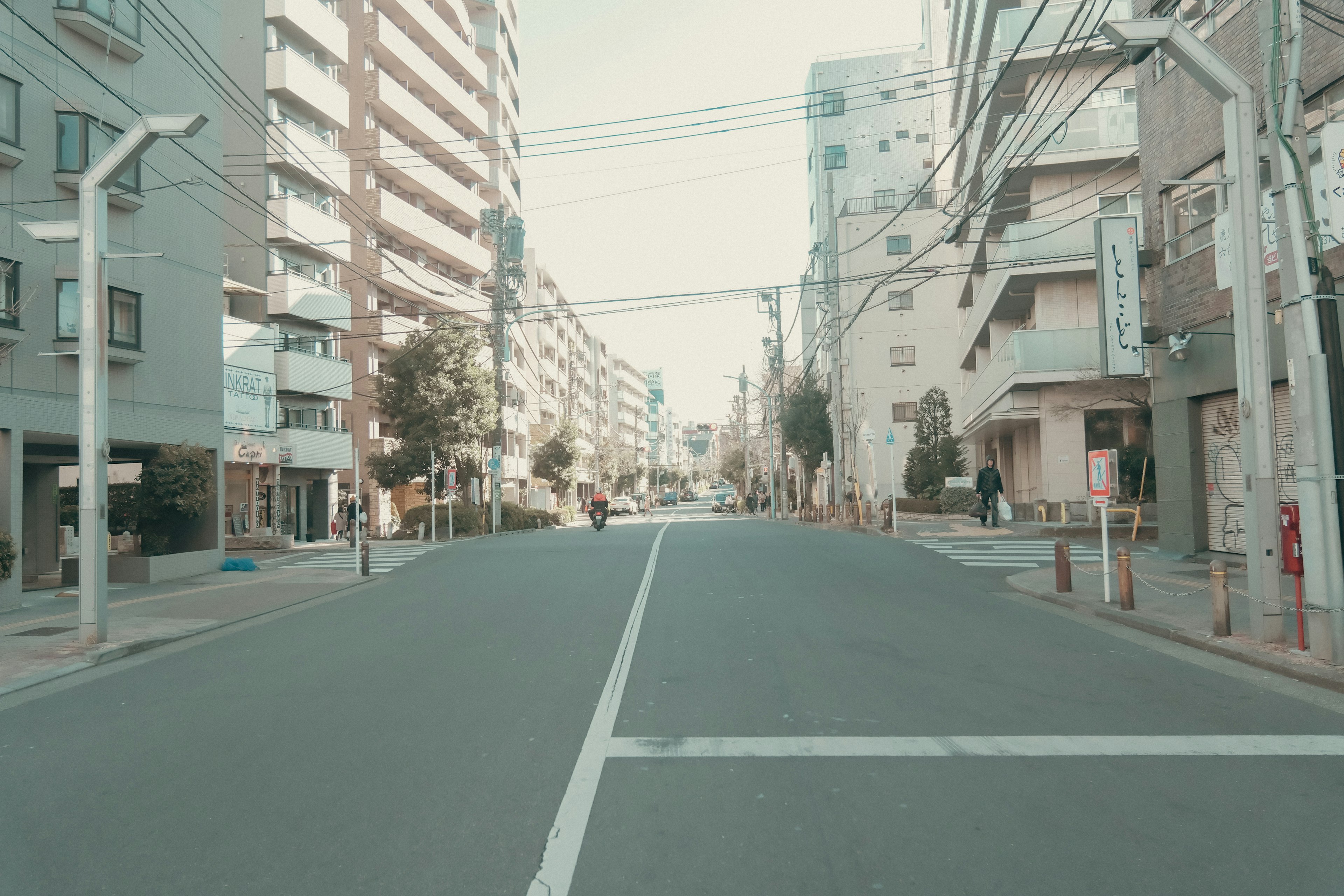 Strada urbana tranquilla fiancheggiata da edifici e linee elettriche