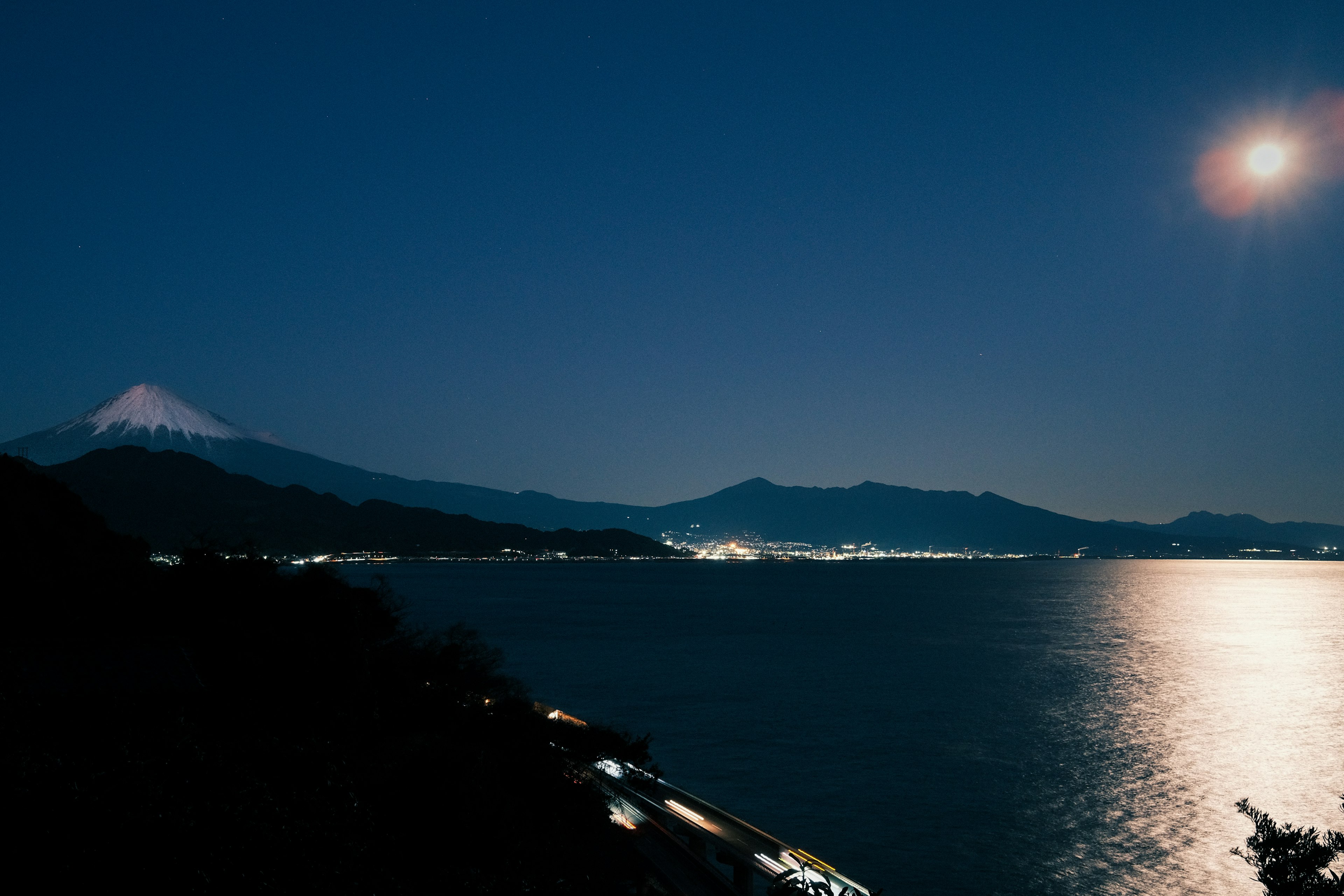 夜の富士山と月明かりが映る湖の風景