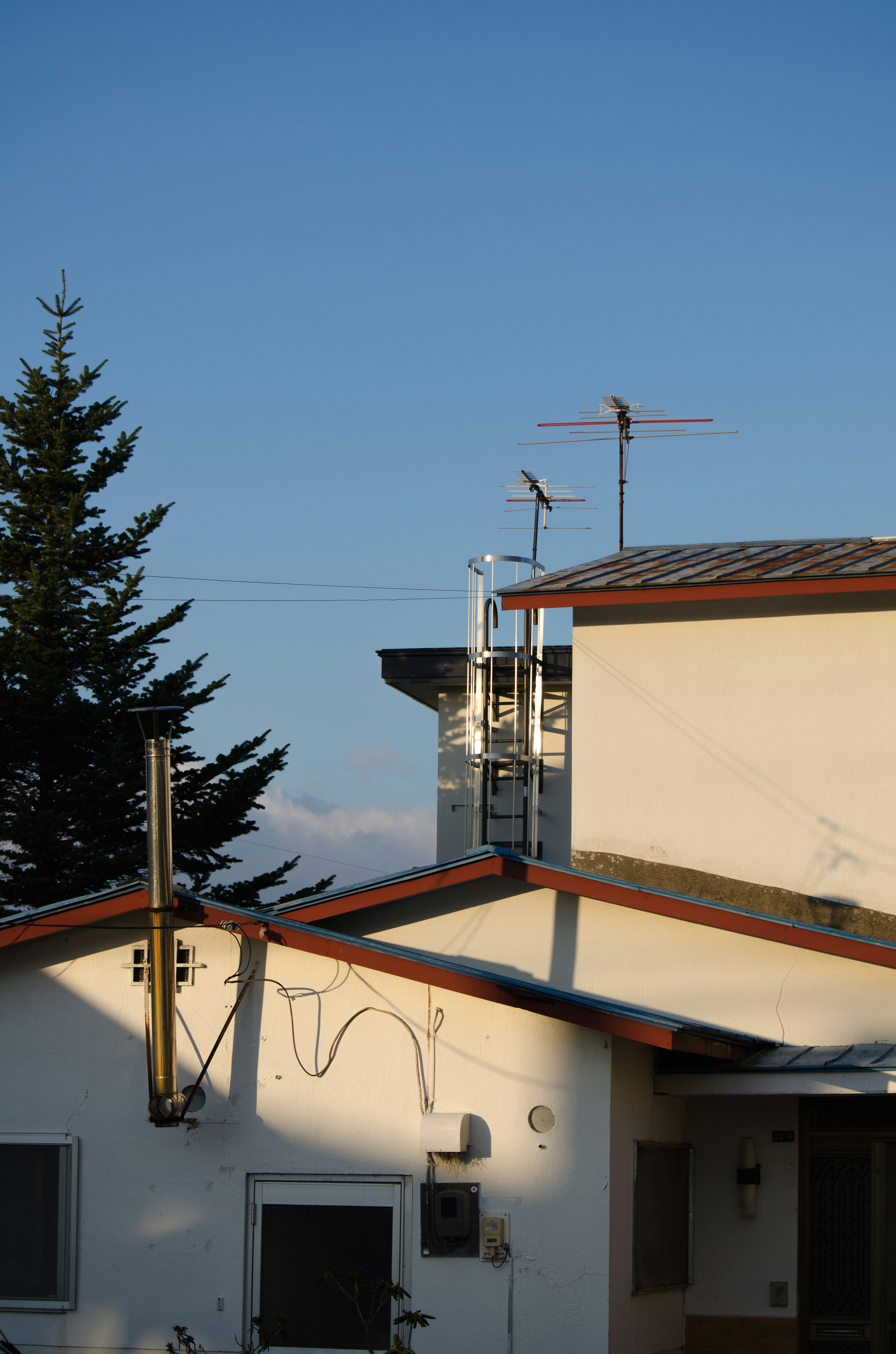 Wohngebäude mit markanten Dächern unter blauem Himmel