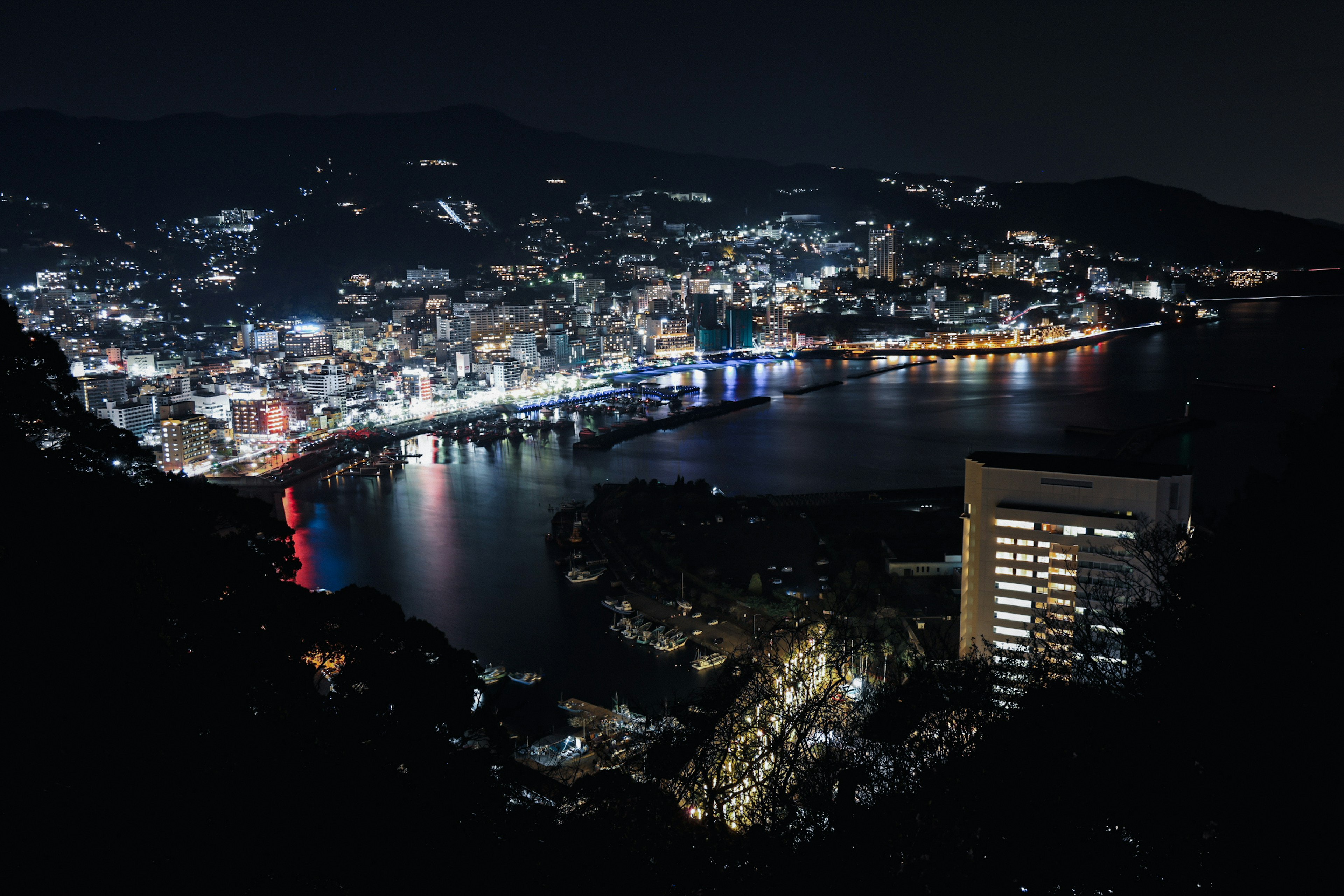 夜の都市景観 美しい光の反映 港と山の景色