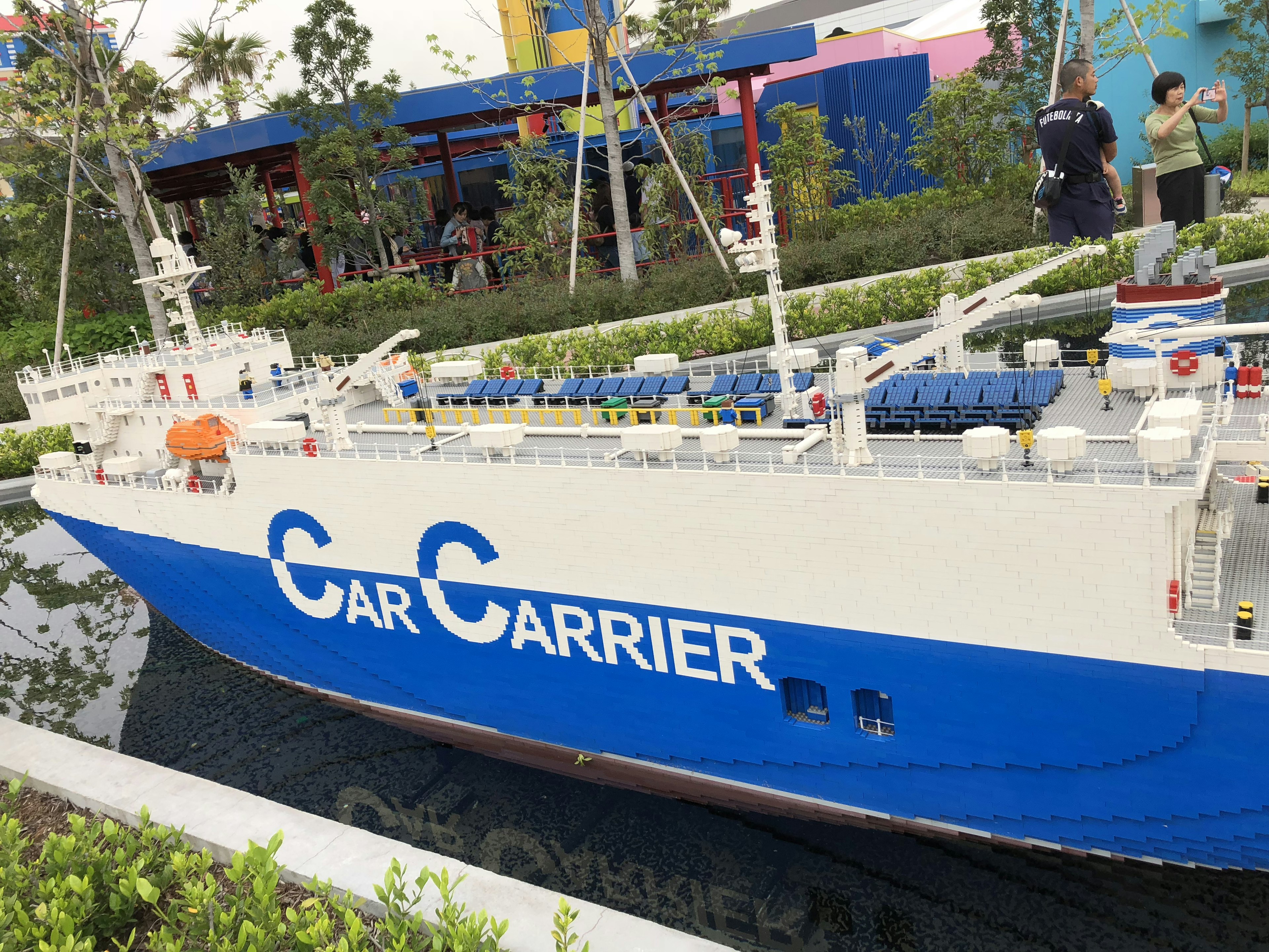 Modello di una nave portacontainer blu e bianca esposto in un giardino