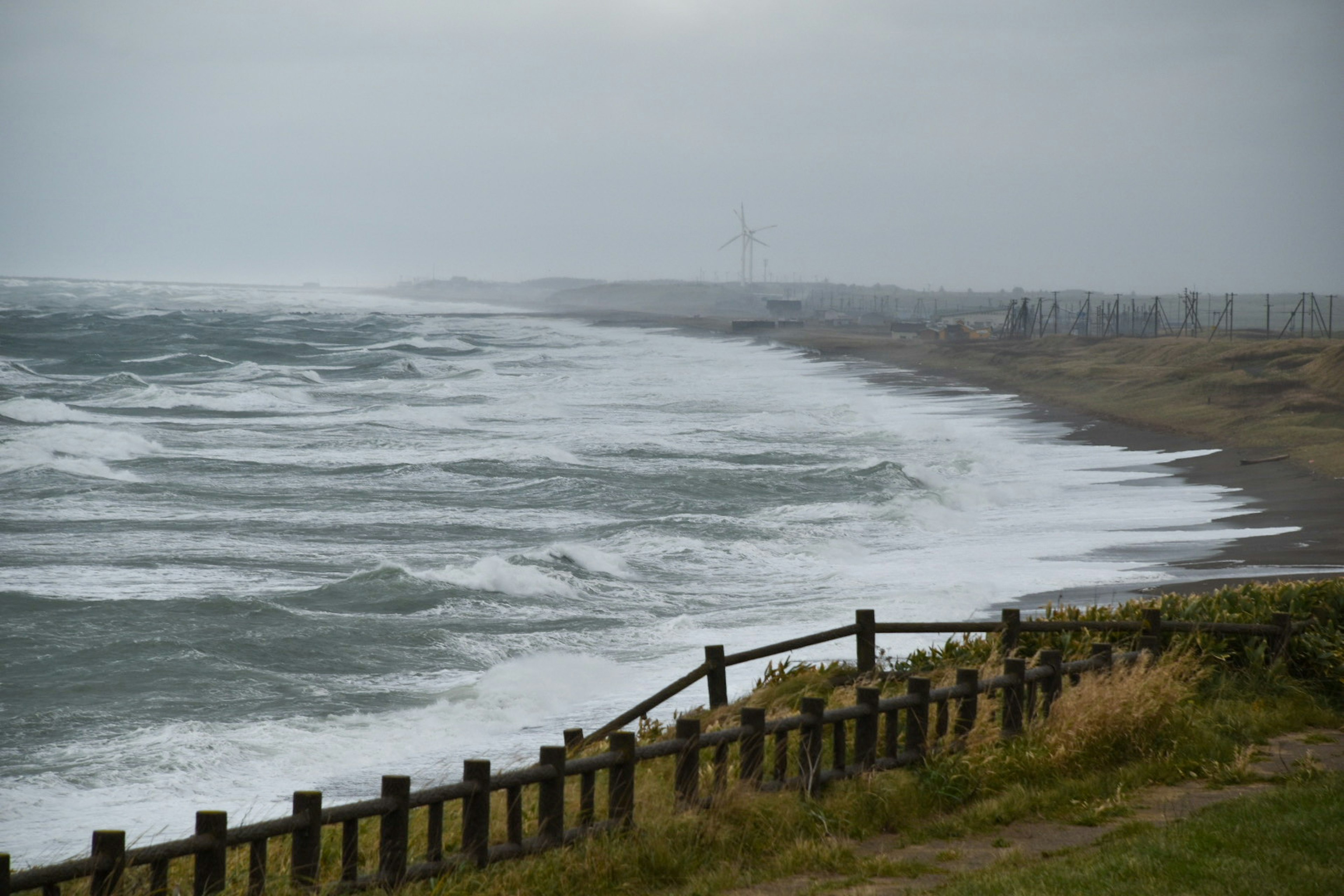 Costa tormentosa con olas rompiendo y cielo nublado