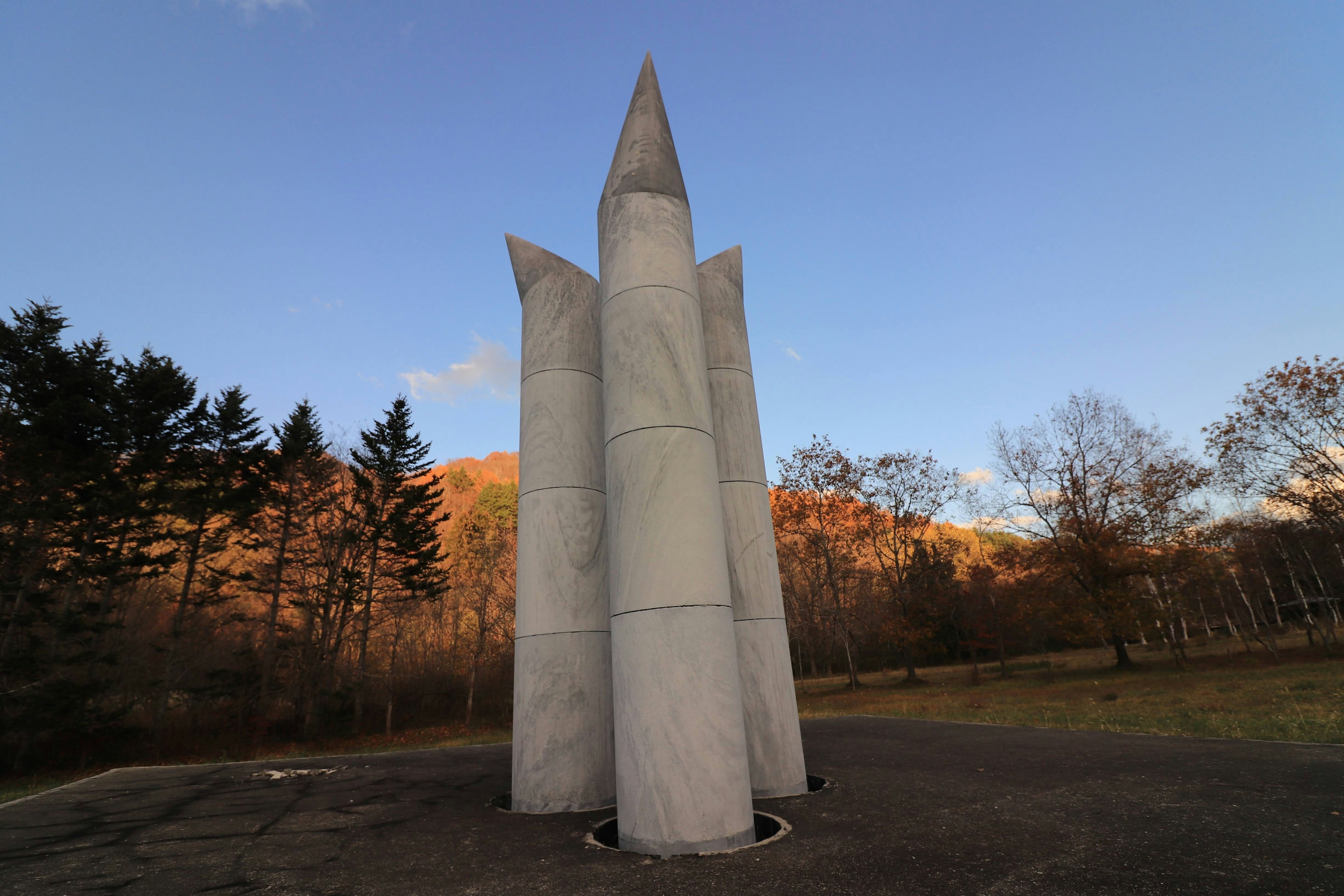 Tall triangular pillar sculpture standing under a blue sky