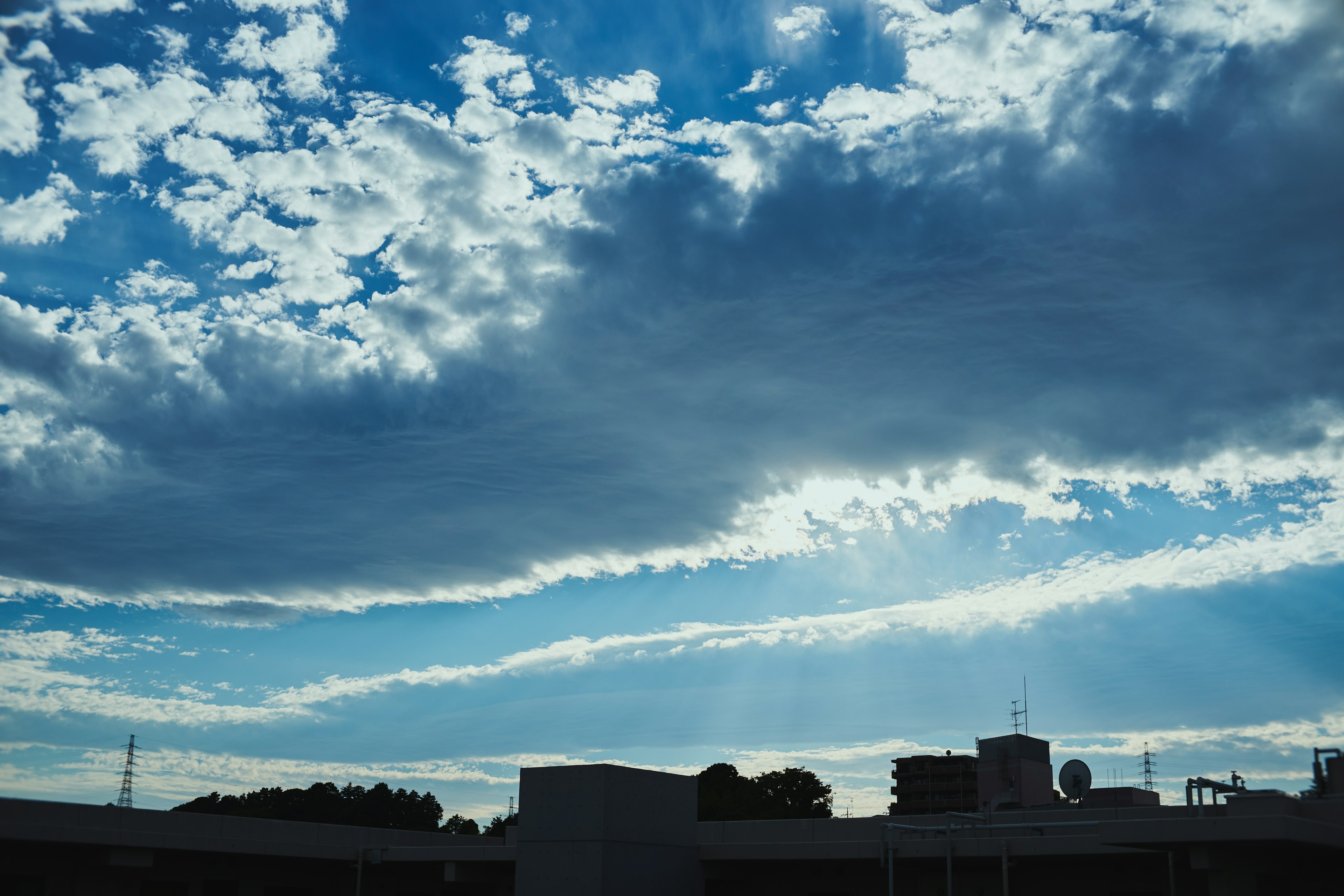 Pemandangan langit biru dengan awan putih dan sinar matahari