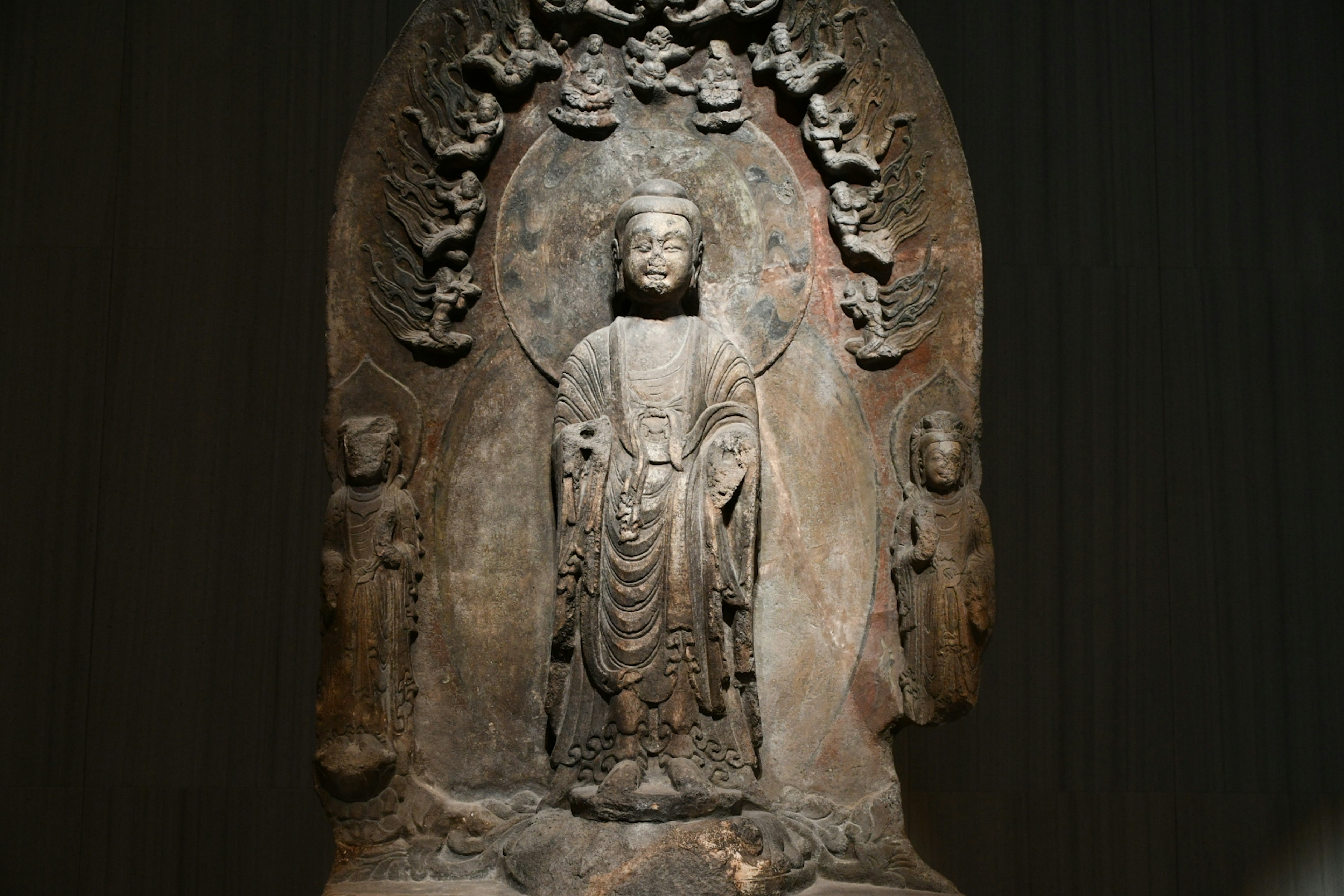 Sculpture of a Buddha figure with two smaller figures on either side