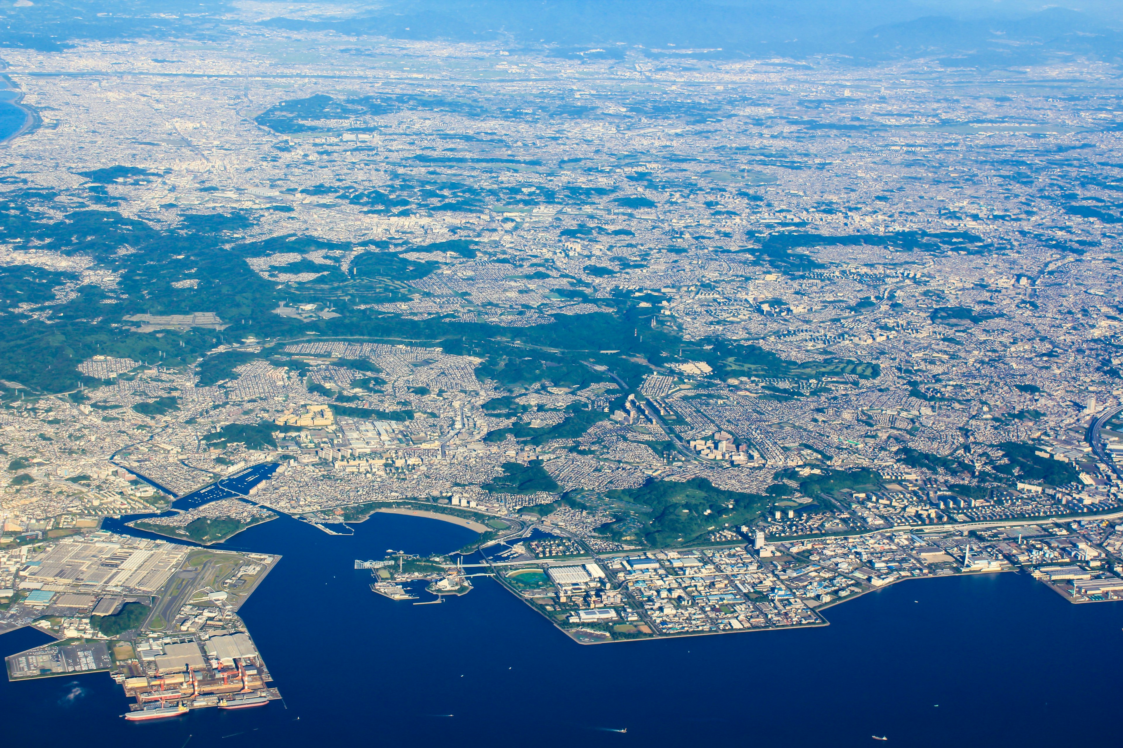 Cảnh quay từ trên cao về Tokyo thể hiện cảnh quan đô thị và đại dương