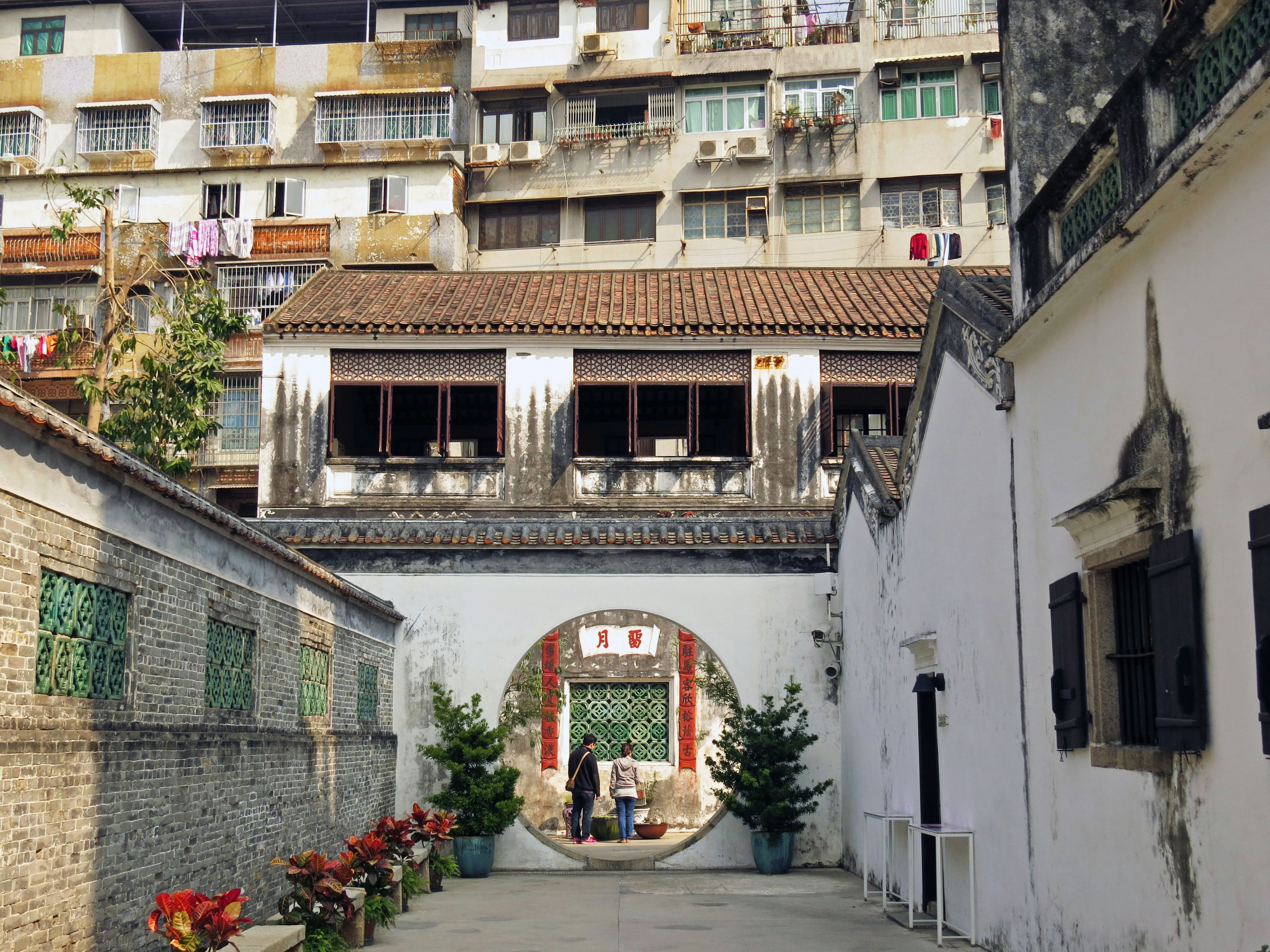 A pathway with traditional architecture and modern buildings in the background