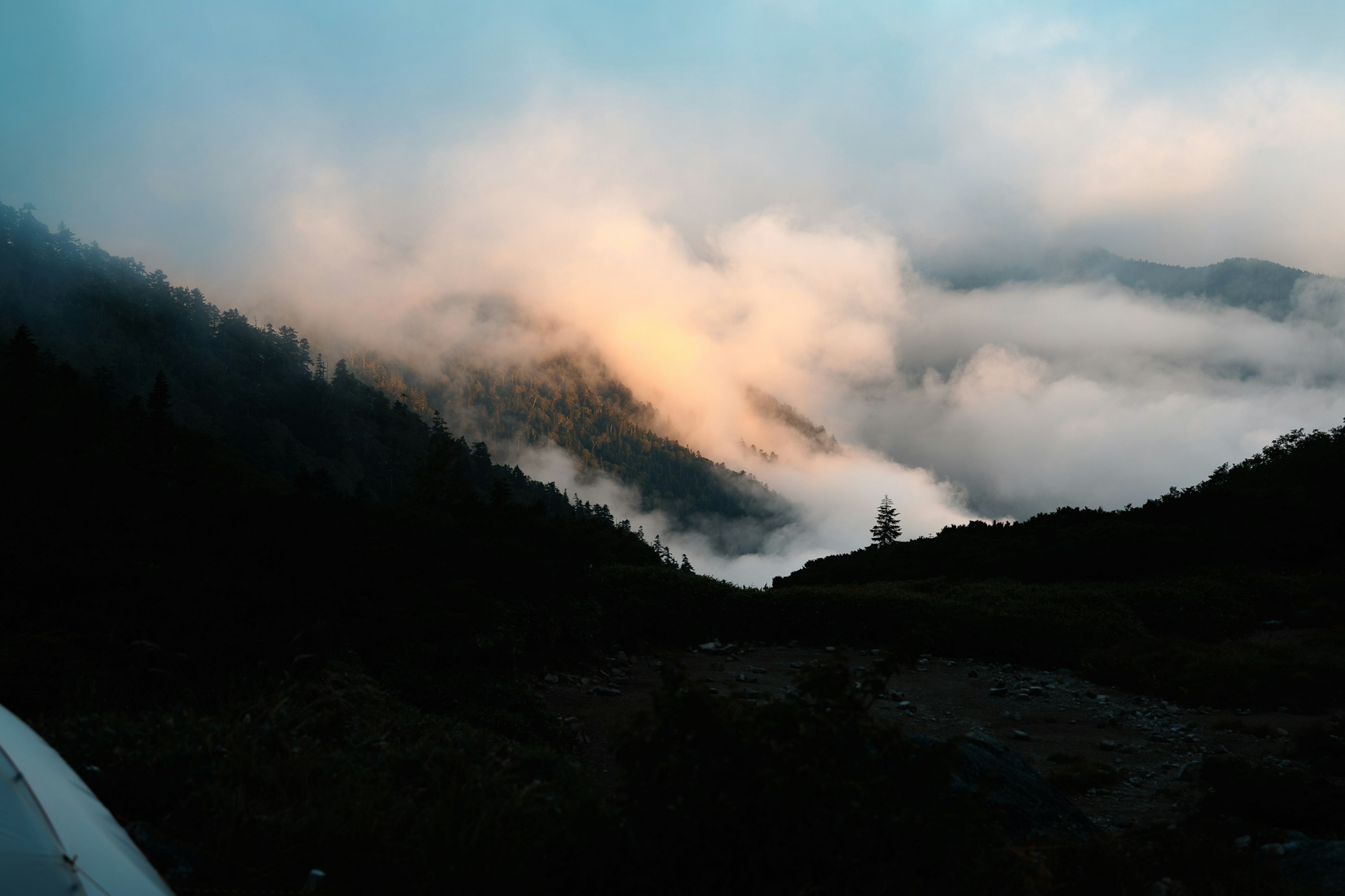 霧に包まれた山々と夕暮れの光