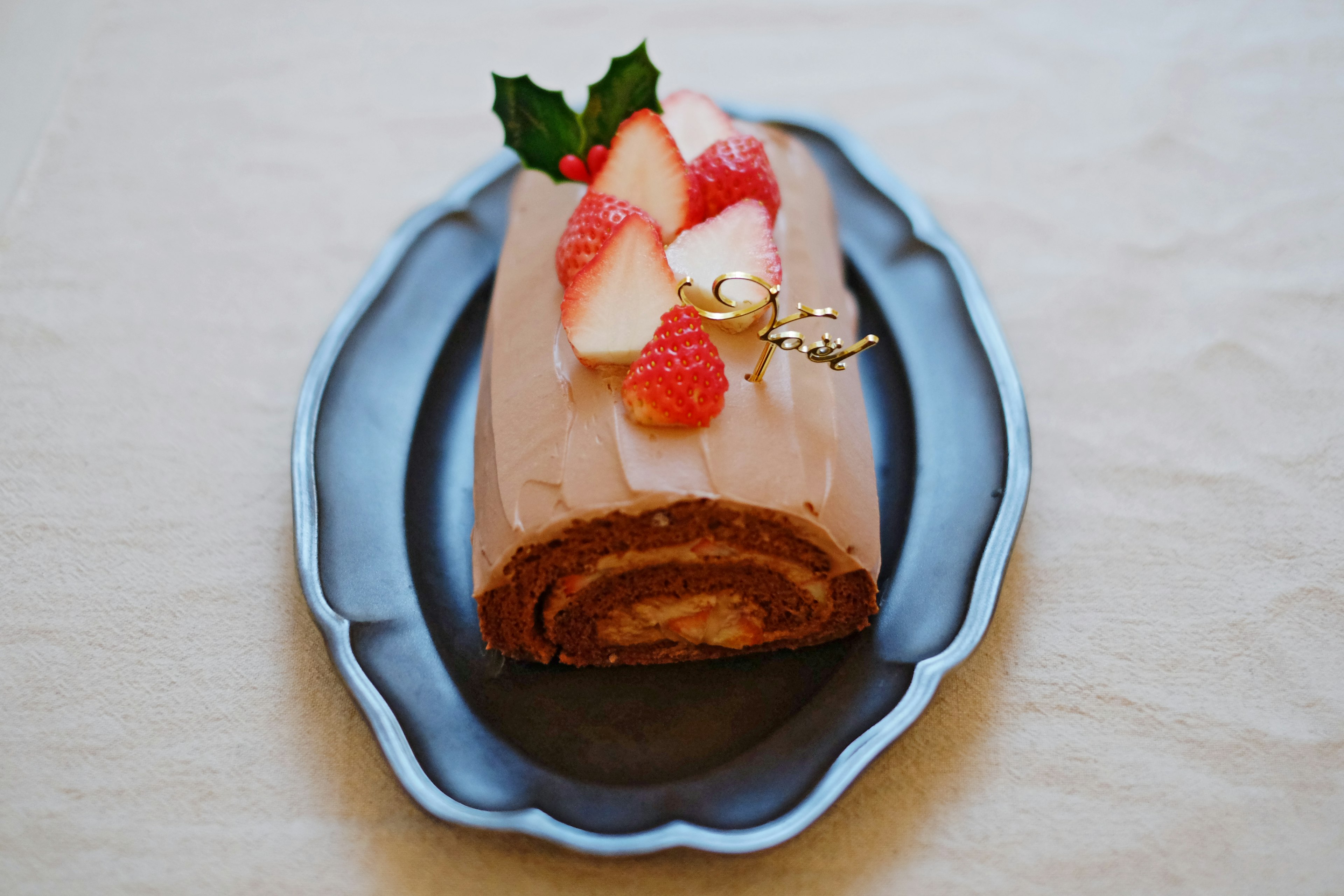 A beautiful dessert roll cake displayed on a blue plate