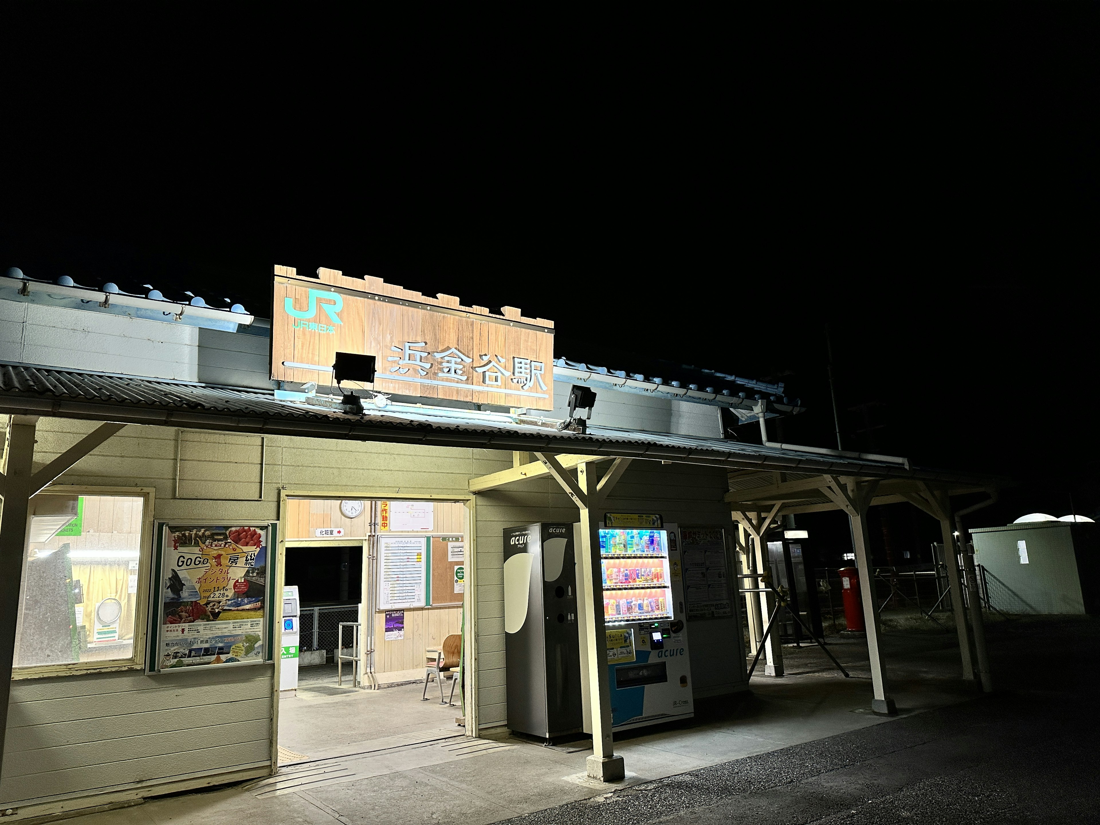 夜の駅の外観 明るい看板と窓が特徴