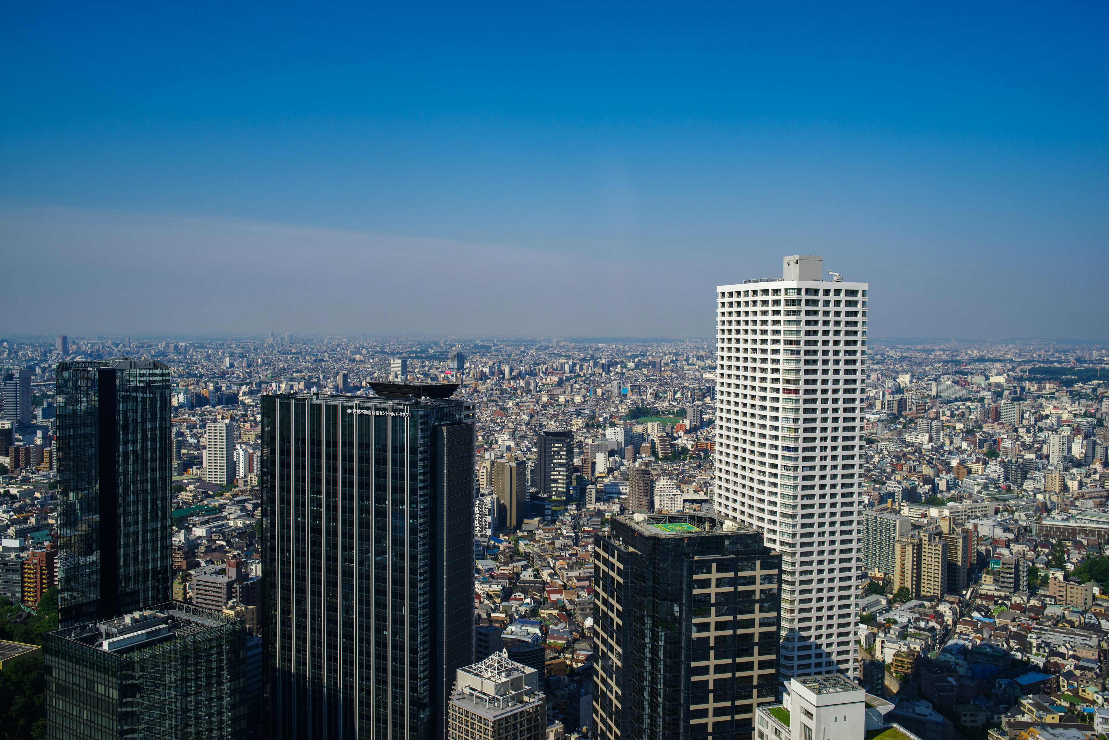 Garis cakrawala Tokyo dengan gedung pencakar langit di bawah langit biru yang cerah