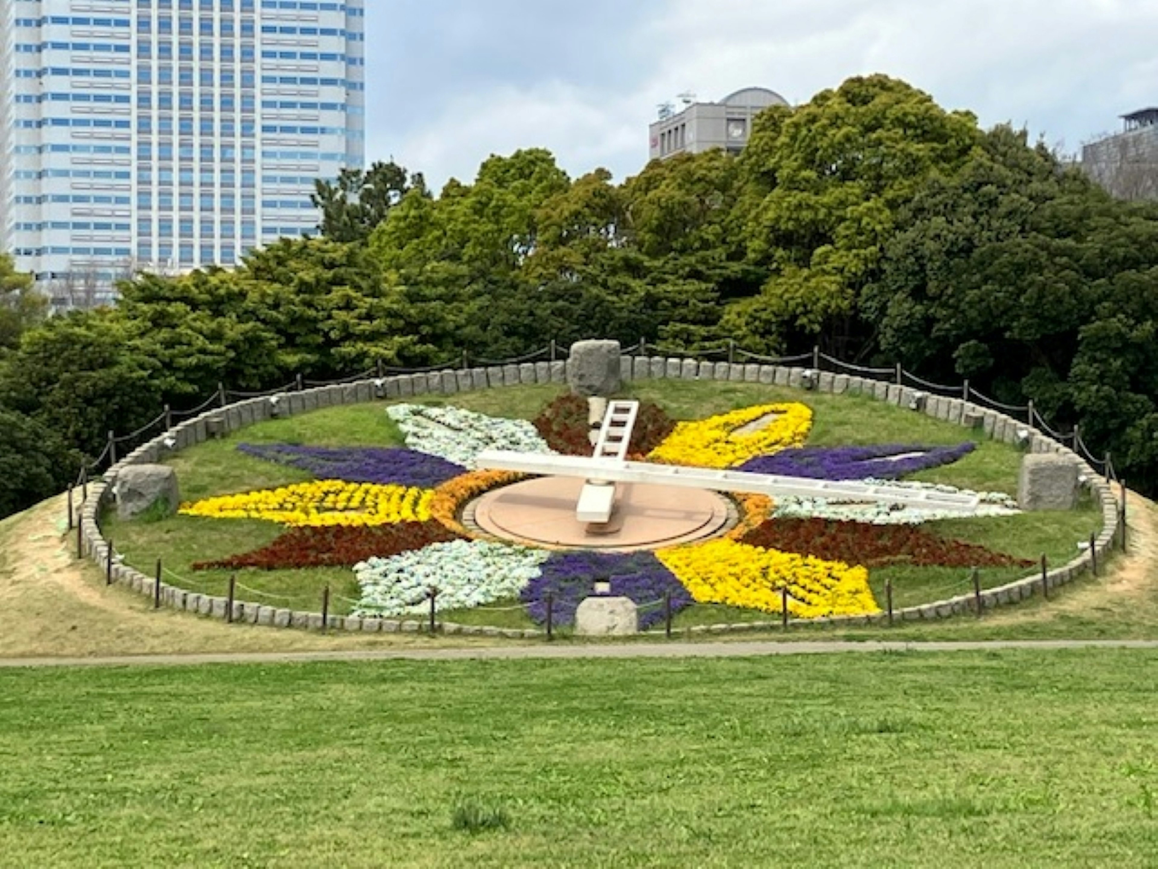 圓形花壇裝飾著五彩繽紛的花朵，周圍是綠色的草地