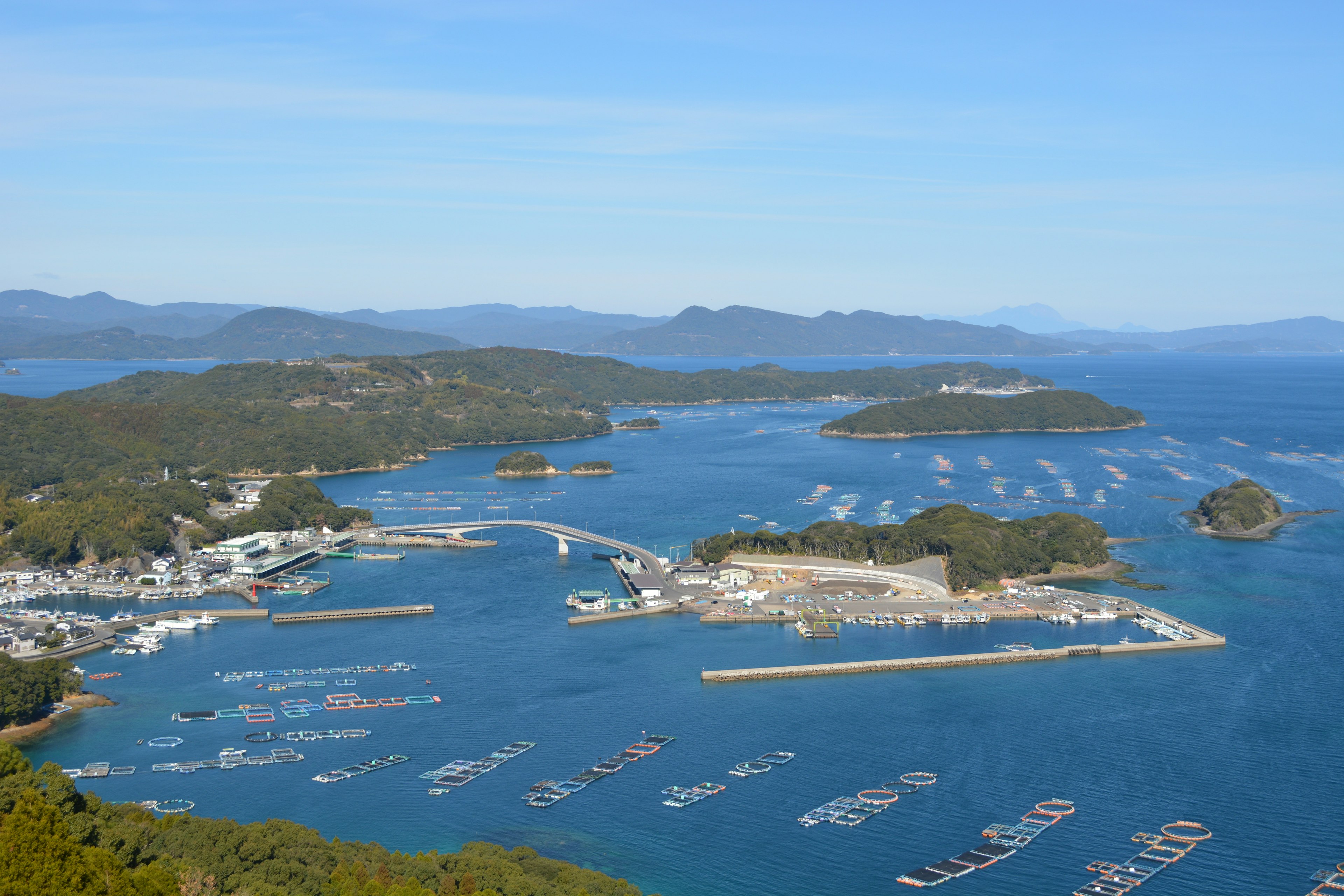 ทิวทัศน์พานอรามาของท่าเรือที่มีทะเลและเกาะที่สวยงามล้อมรอบ