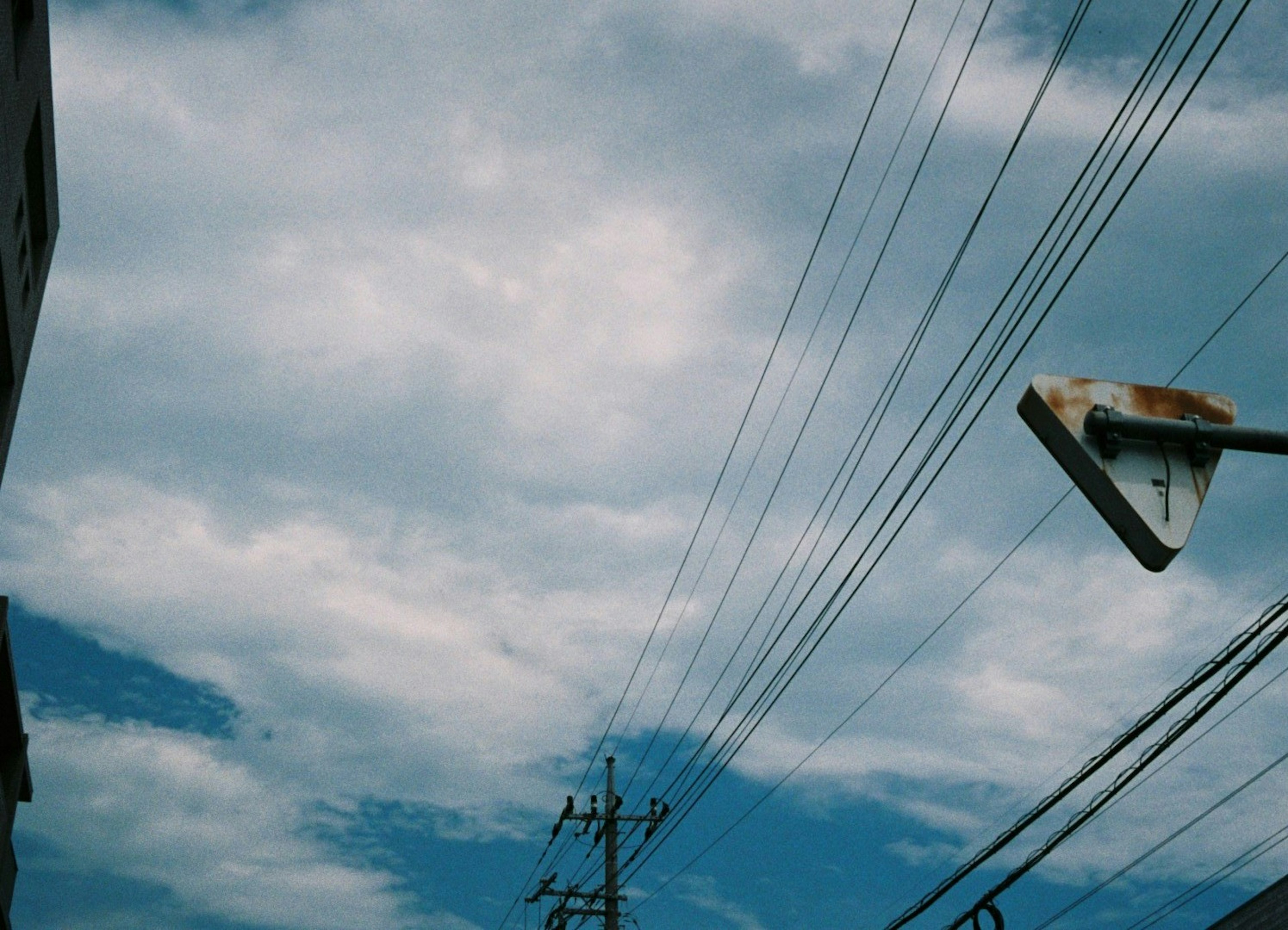 Cielo con nubes que muestra líneas eléctricas y una farola