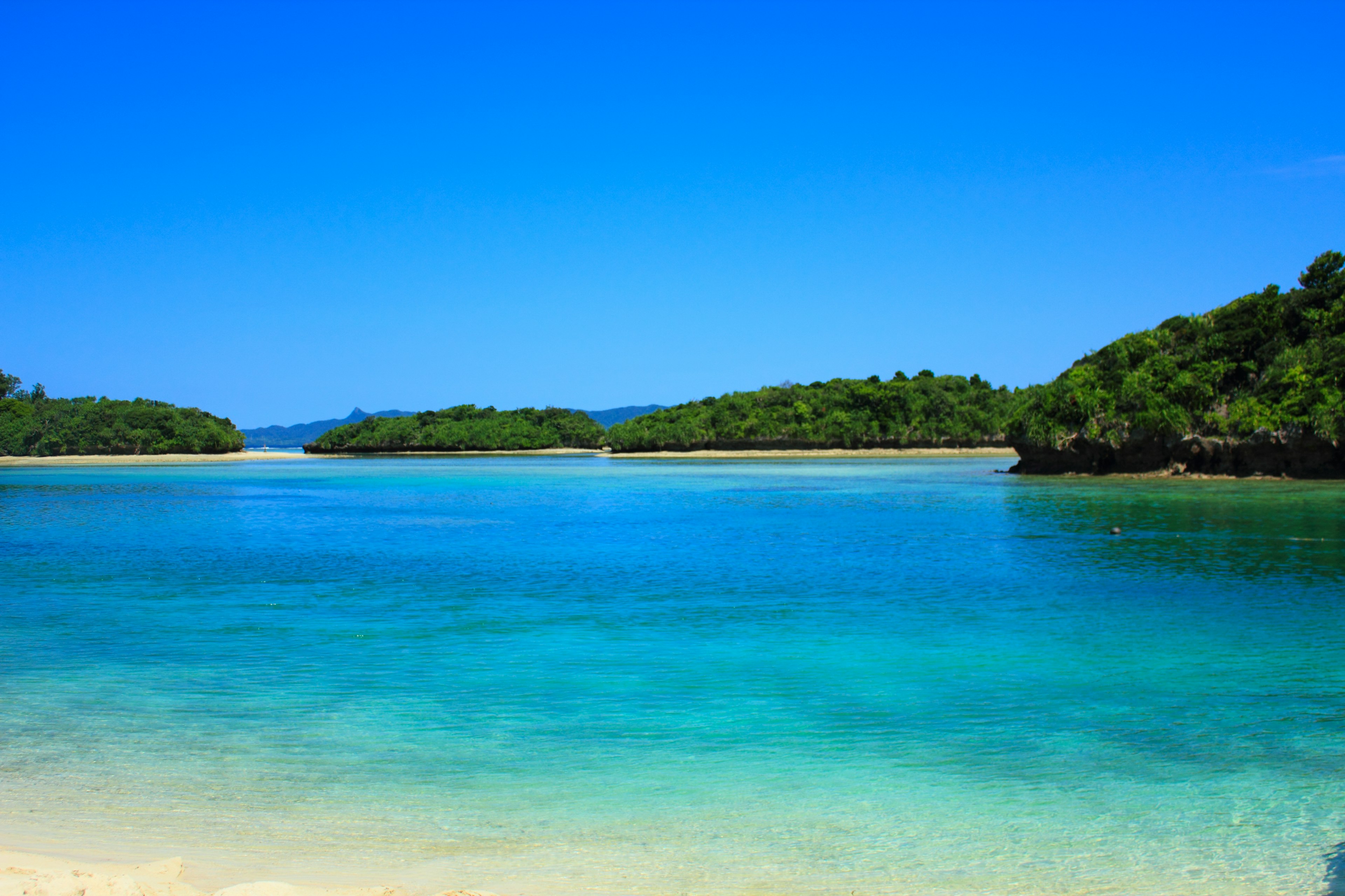 Schöne Strandlandschaft mit blauem Ozean und grünen Inseln