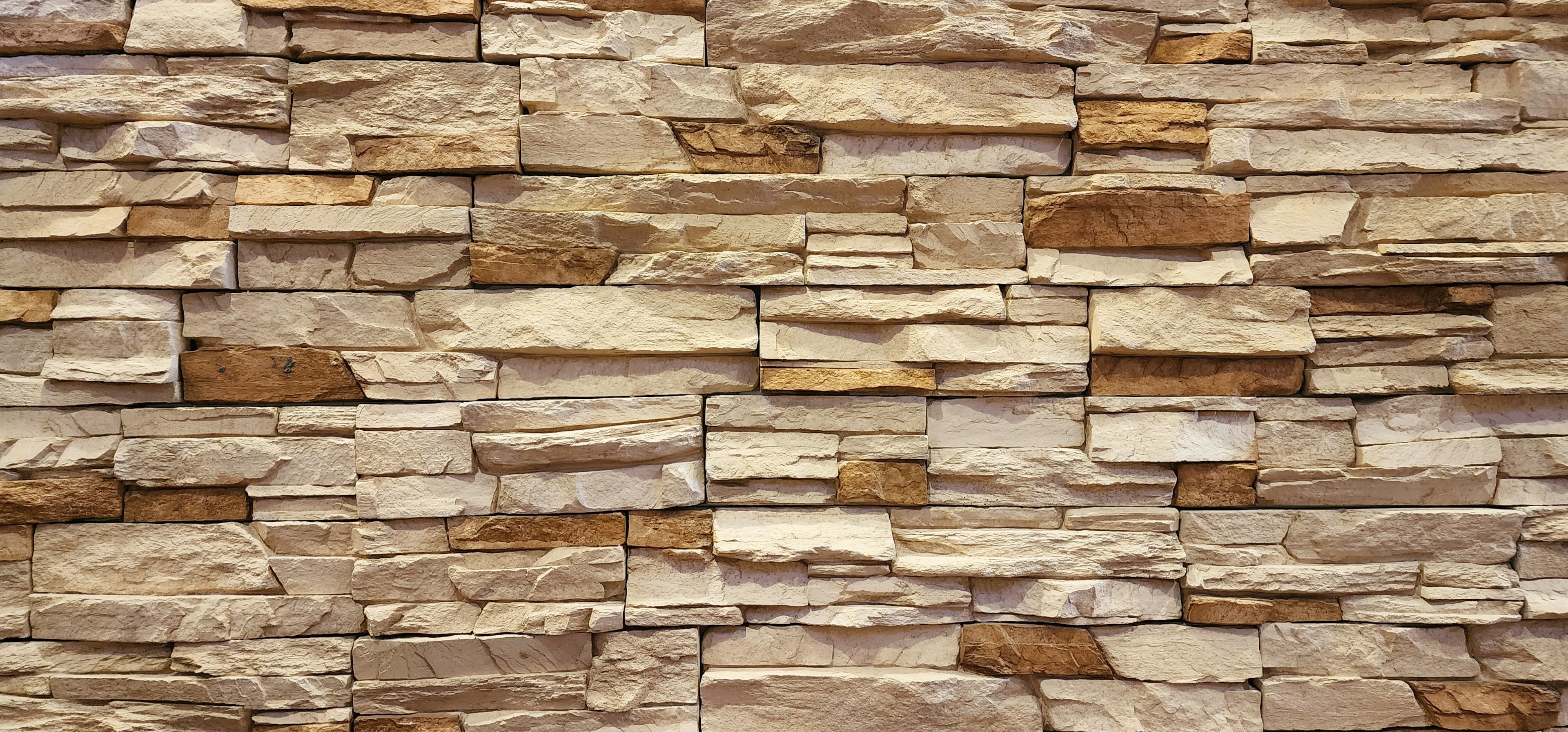 Textured wall made of natural stones showcasing various shades